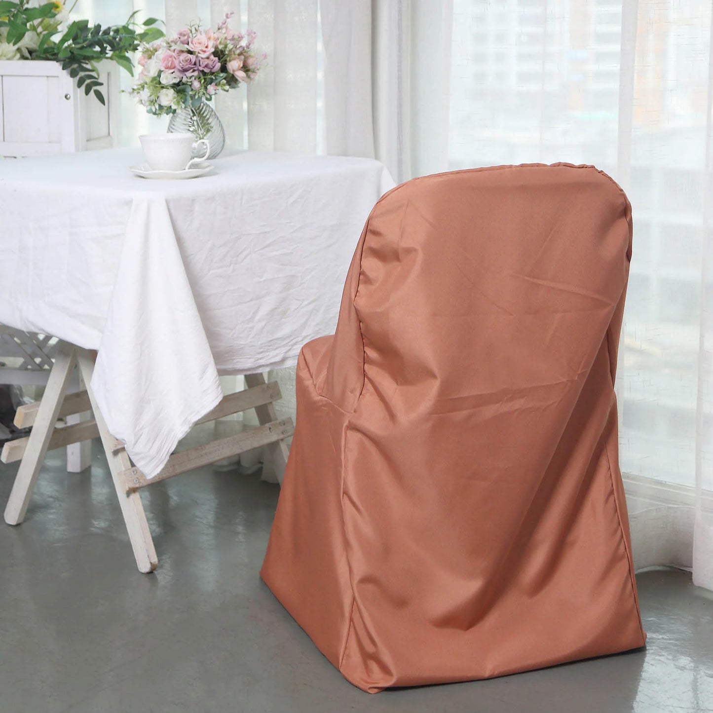 Terracotta polyester folding chair cover on a dining chair.
