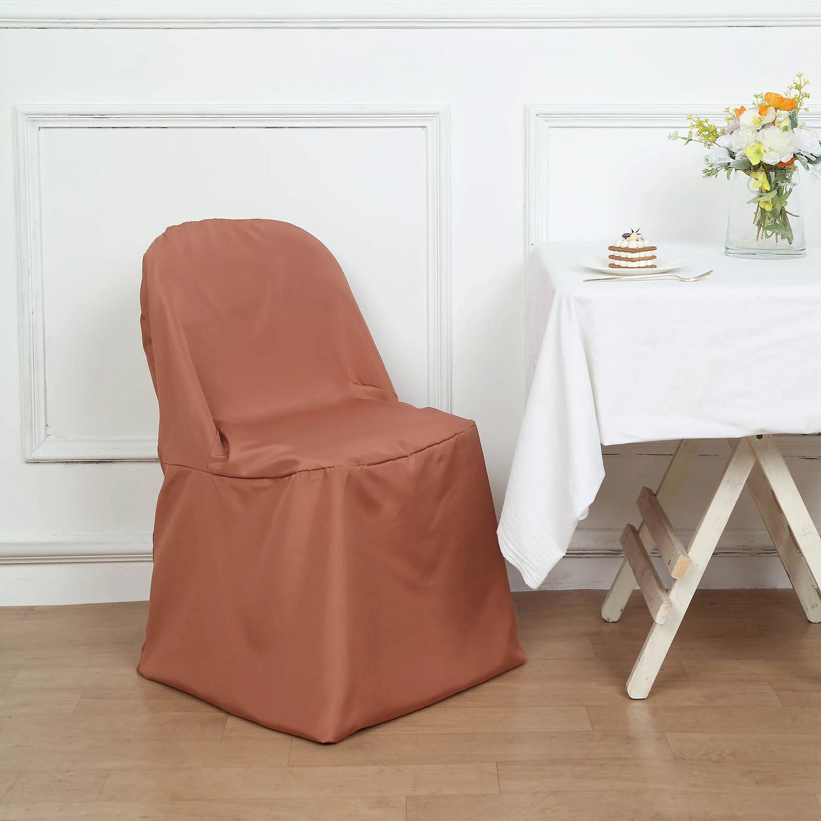 Terracotta polyester folding chair cover on a wooden floor.