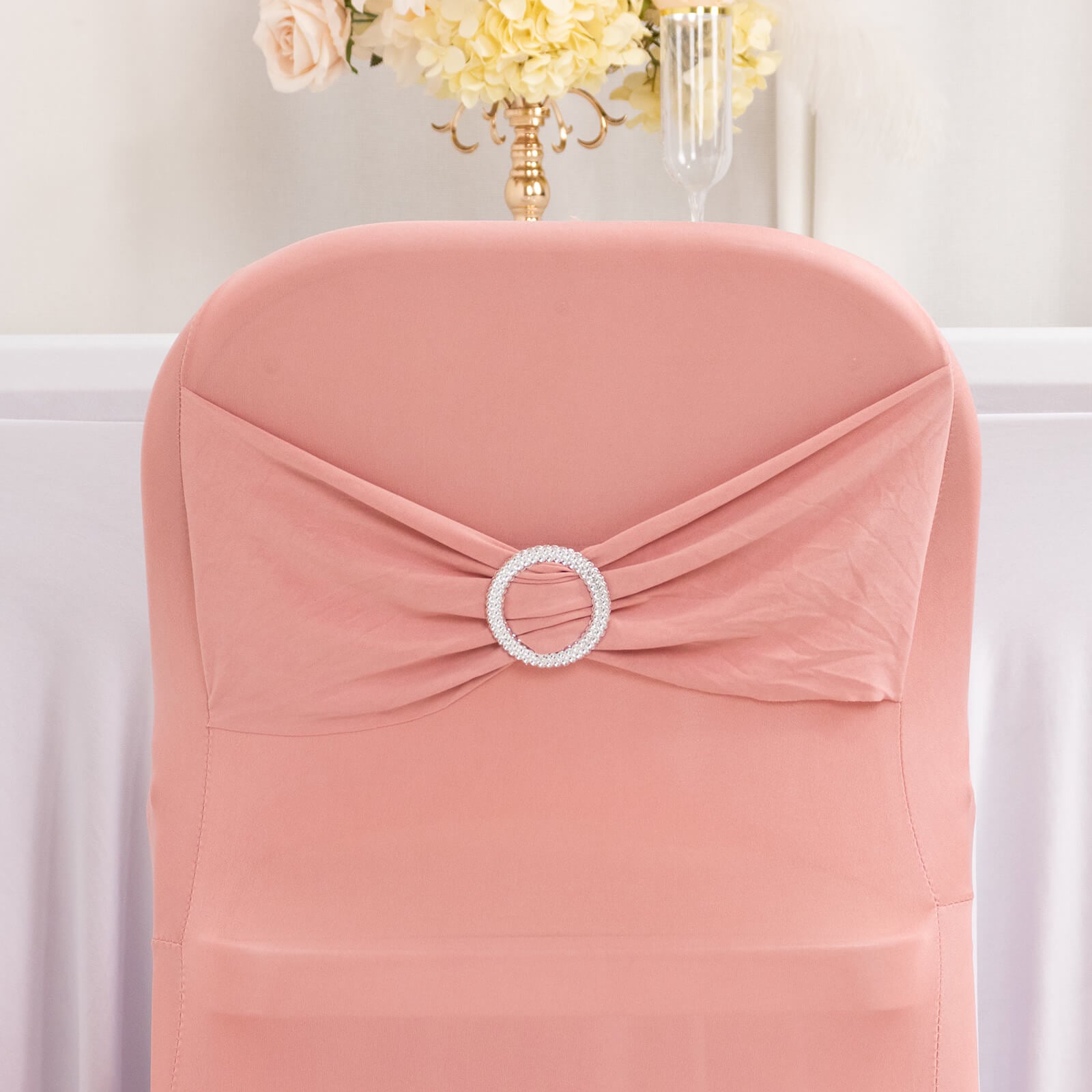 Blush spandex chair cover with silver rhinestone sash detail.