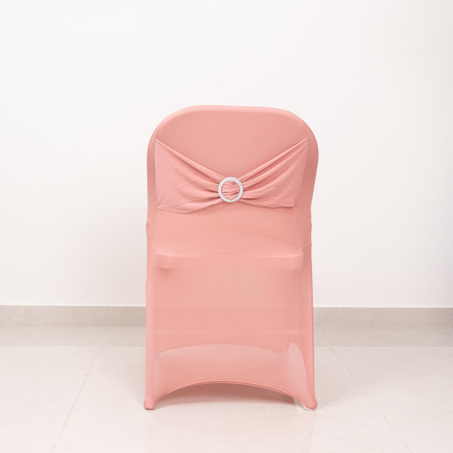 Blush spandex folding chair cover with rhinestone sash band.