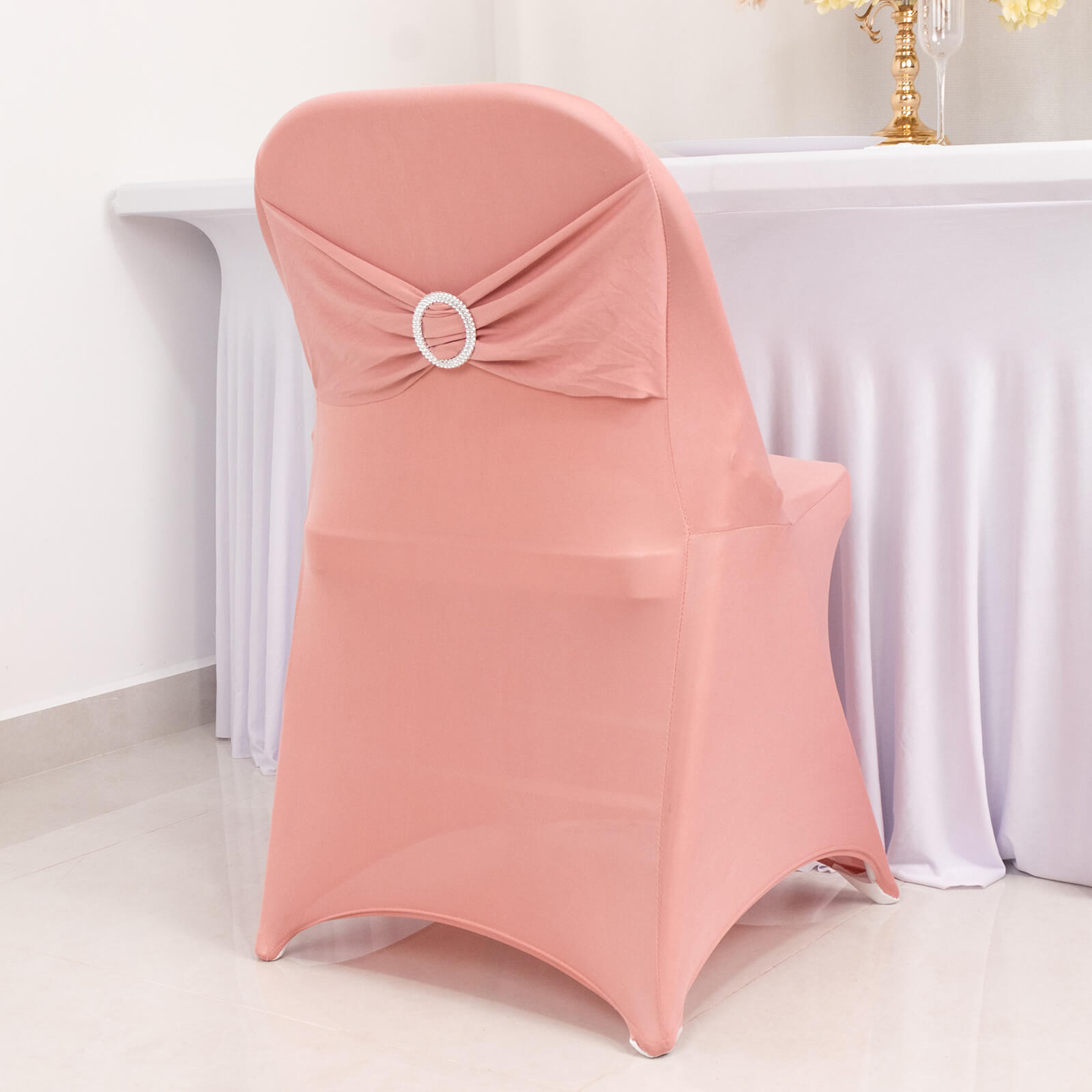 Blush spandex folding chair cover with silver rhinestone sash.