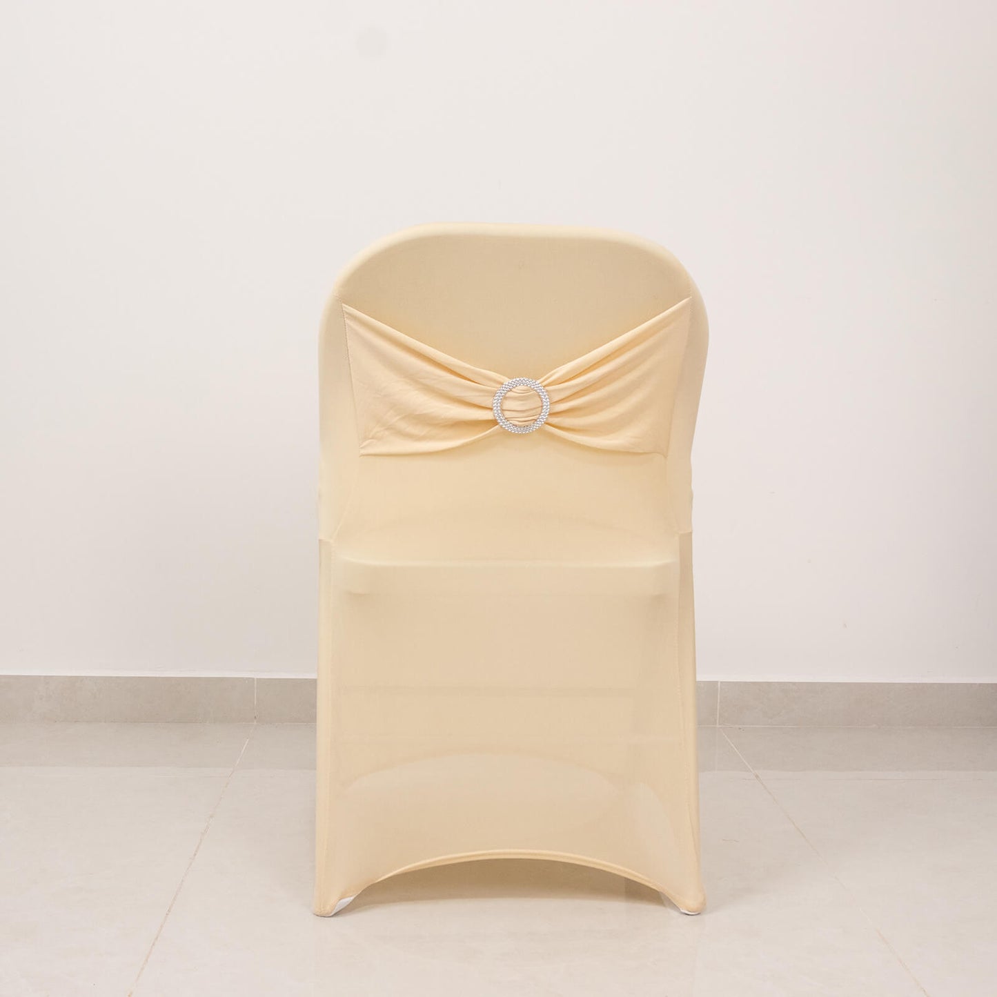 Beige folding chair cover with silver rhinestone sash.