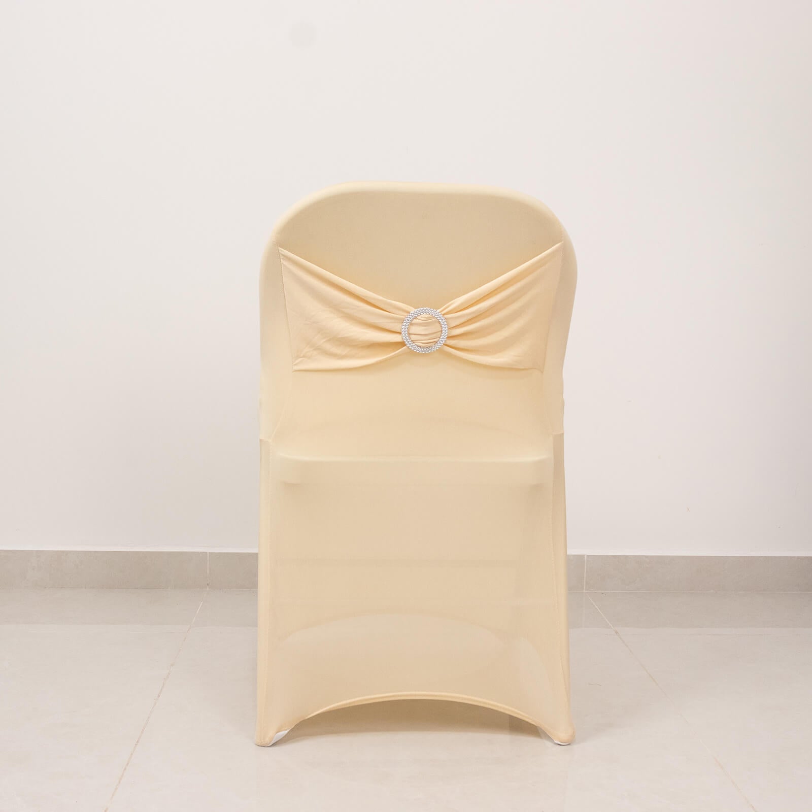 Beige folding chair cover with silver rhinestone sash.