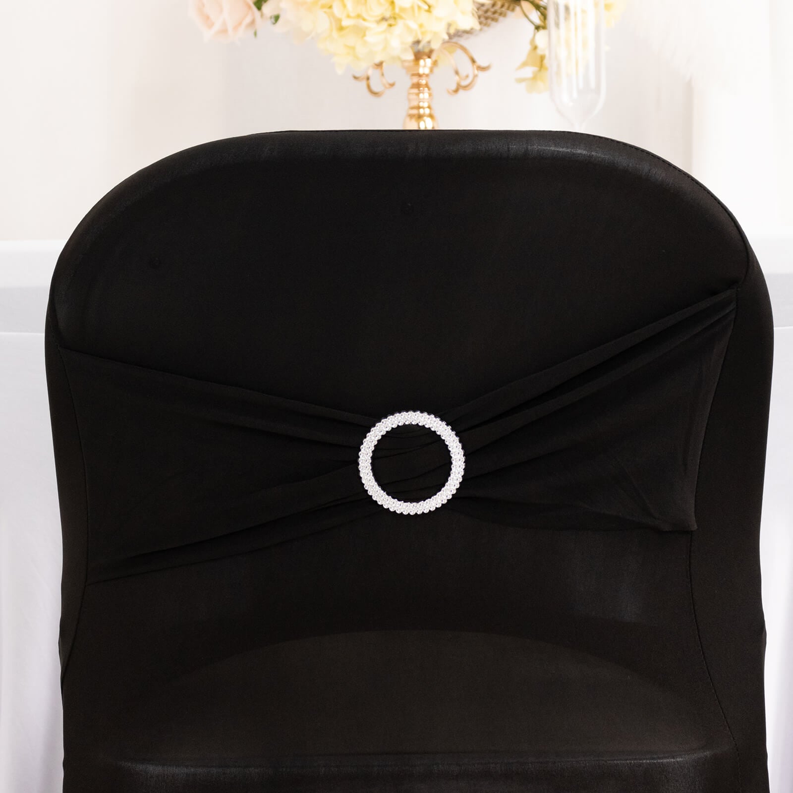 Black spandex chair cover with silver rhinestone sash.