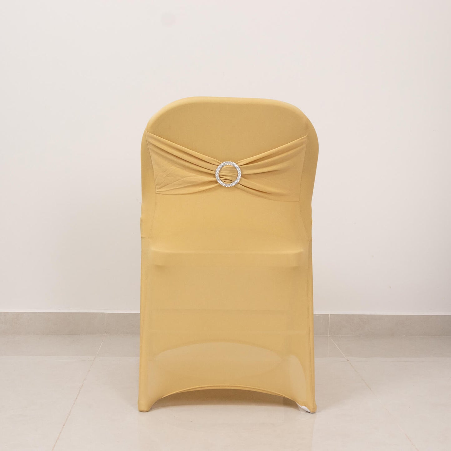 Champagne folding chair cover with silver rhinestone sash.