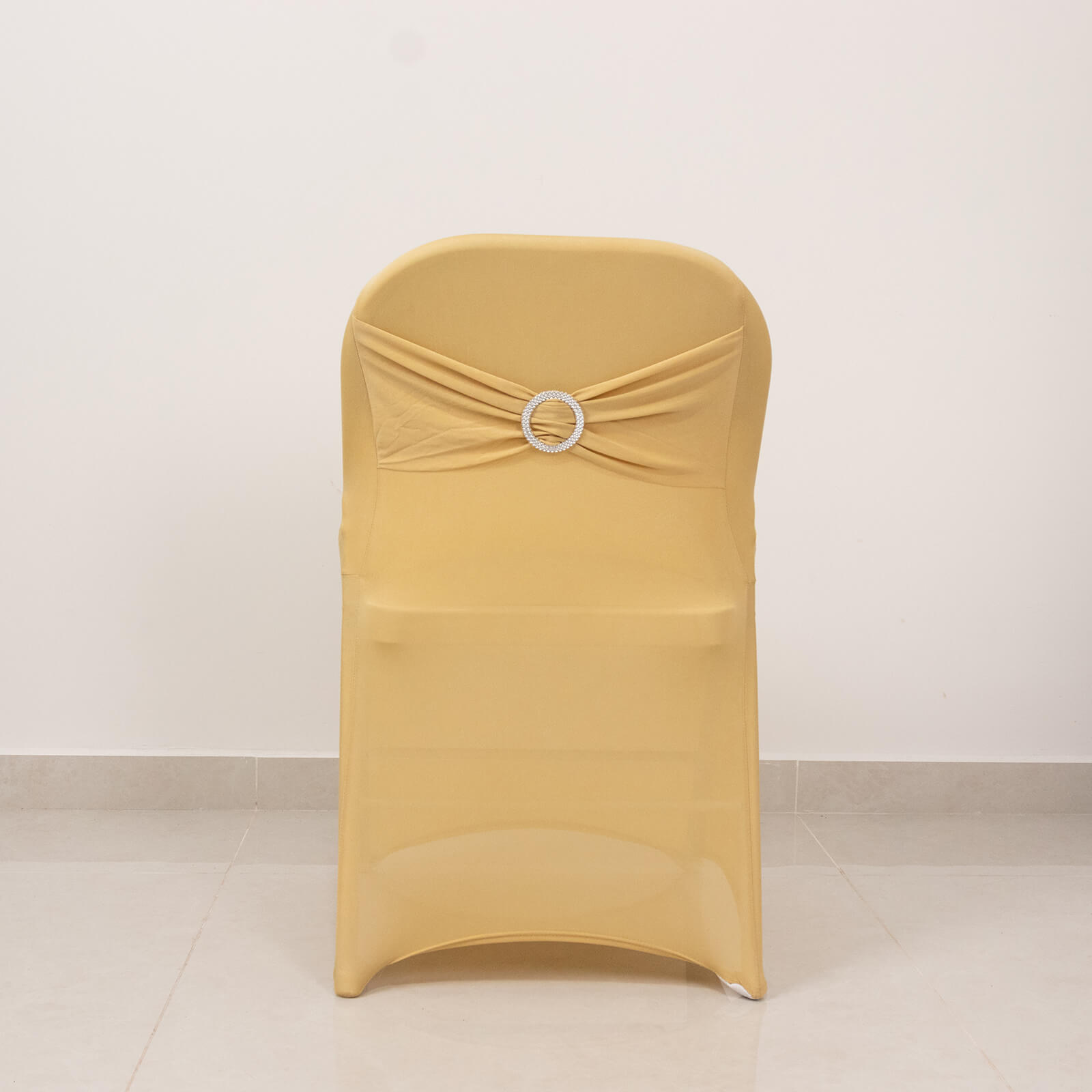 Champagne folding chair cover with silver rhinestone sash.