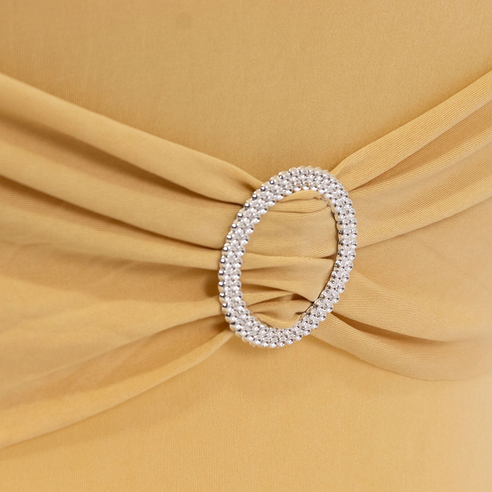 Champagne folding chair cover with silver rhinestone buckle detail.