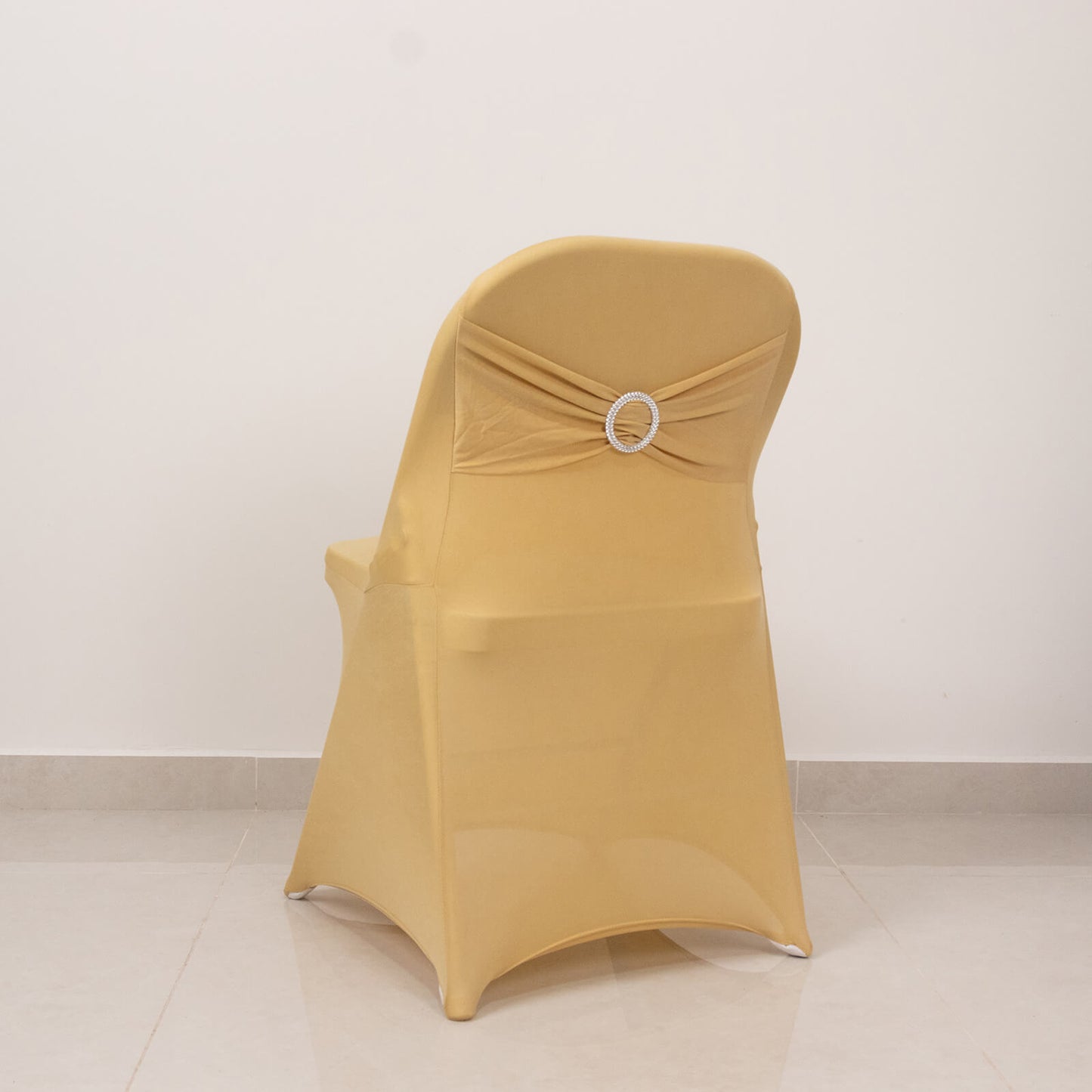 Champagne spandex chair cover with silver rhinestone sash.