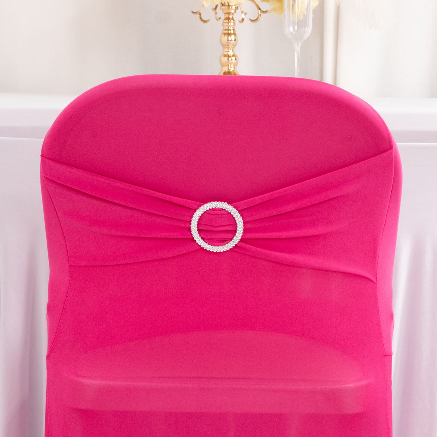 Fuchsia spandex chair cover with silver rhinestone buckle detail.