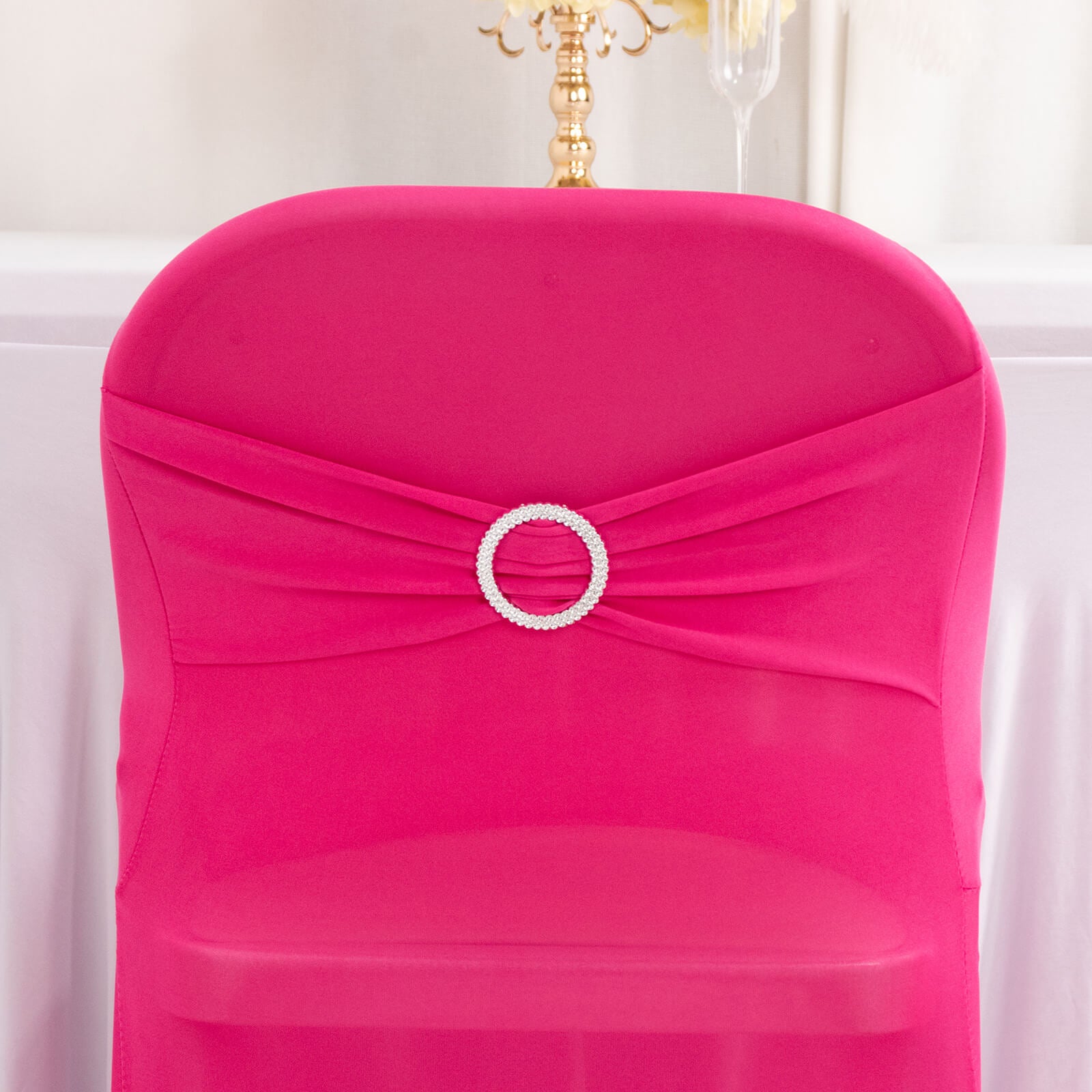 Fuchsia spandex chair cover with silver rhinestone buckle detail.