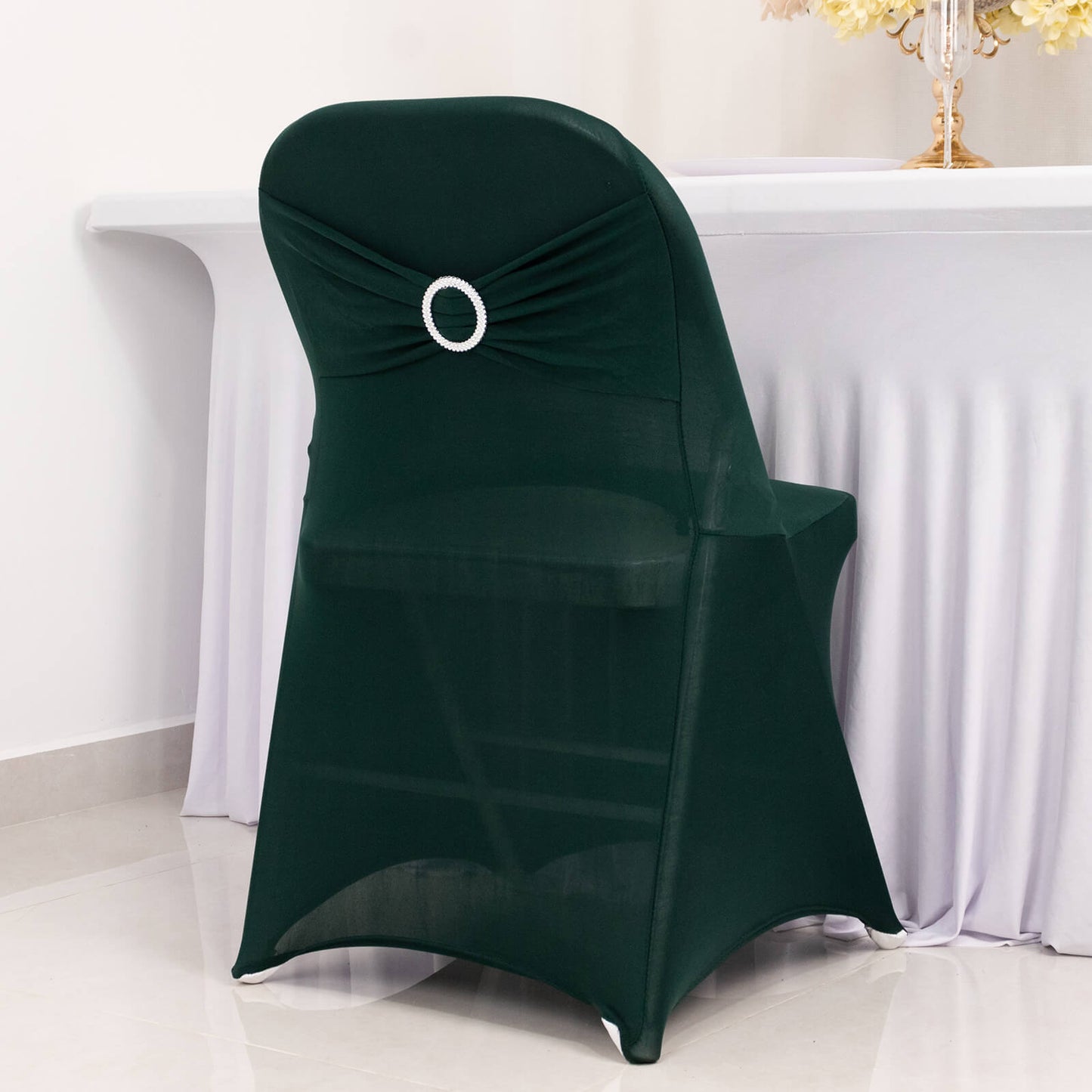 Emerald green spandex folding chair cover with rhinestone sash.