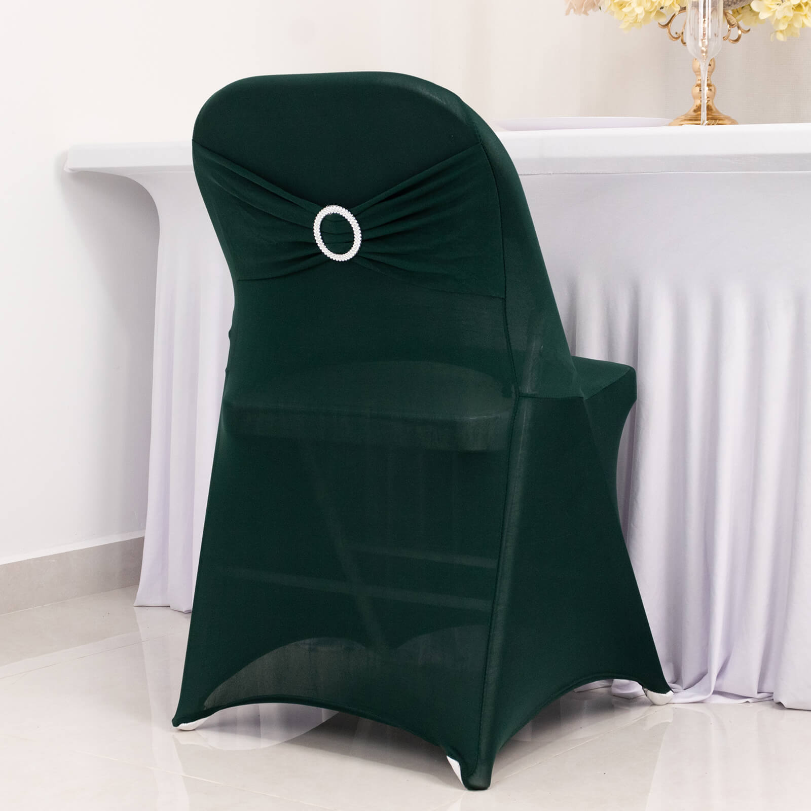 Emerald green spandex folding chair cover with rhinestone sash.