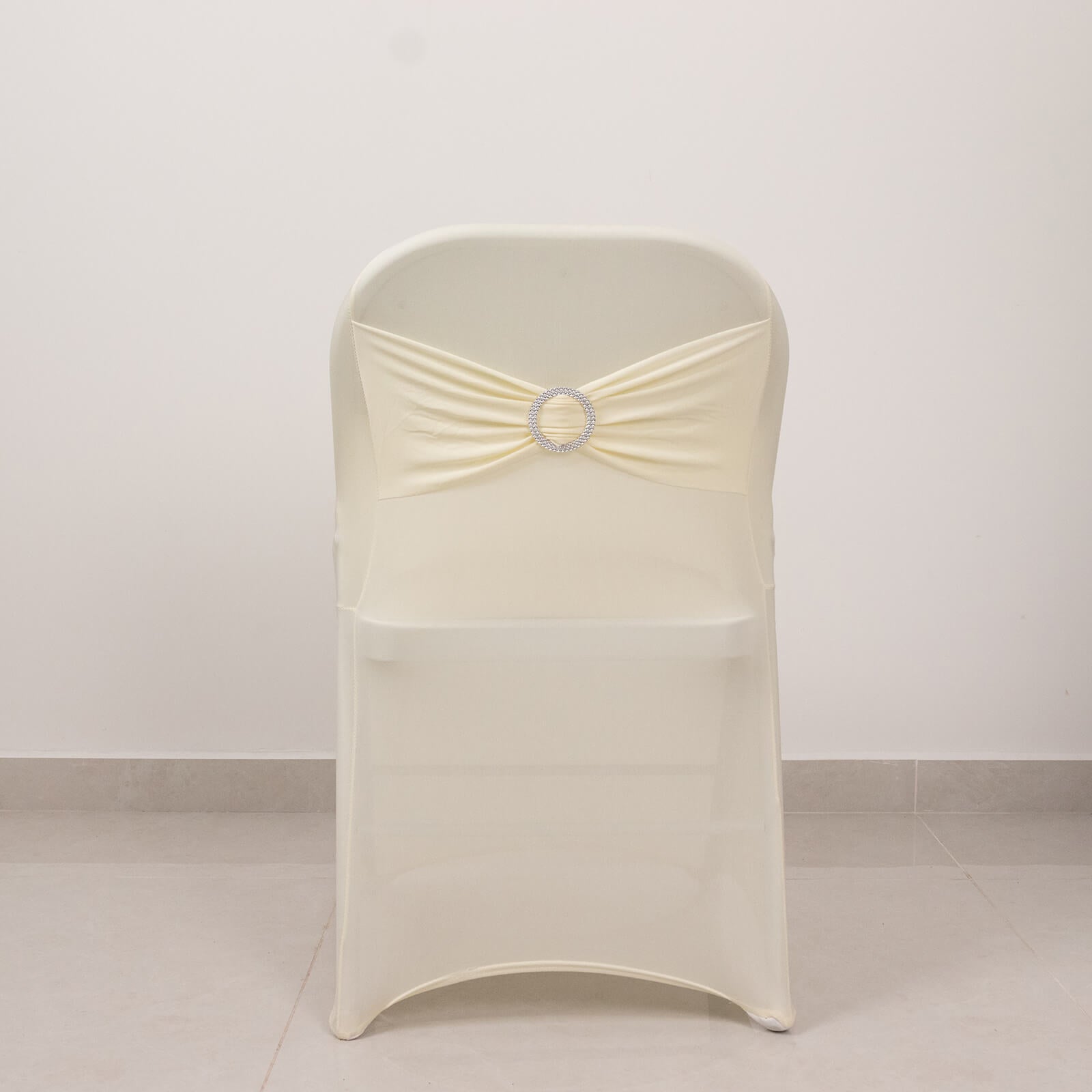 Ivory spandex folding chair cover with rhinestone buckle.