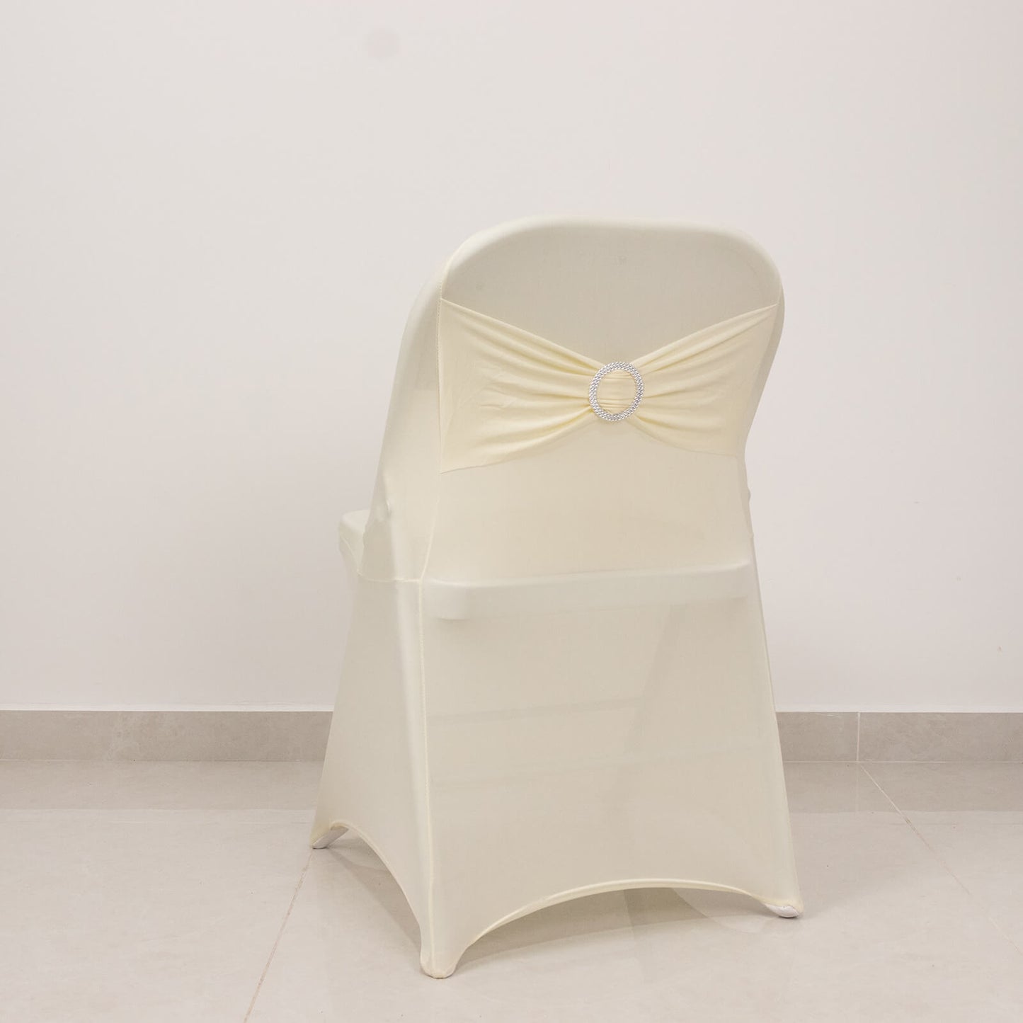 Ivory spandex chair cover with silver rhinestone sash band.