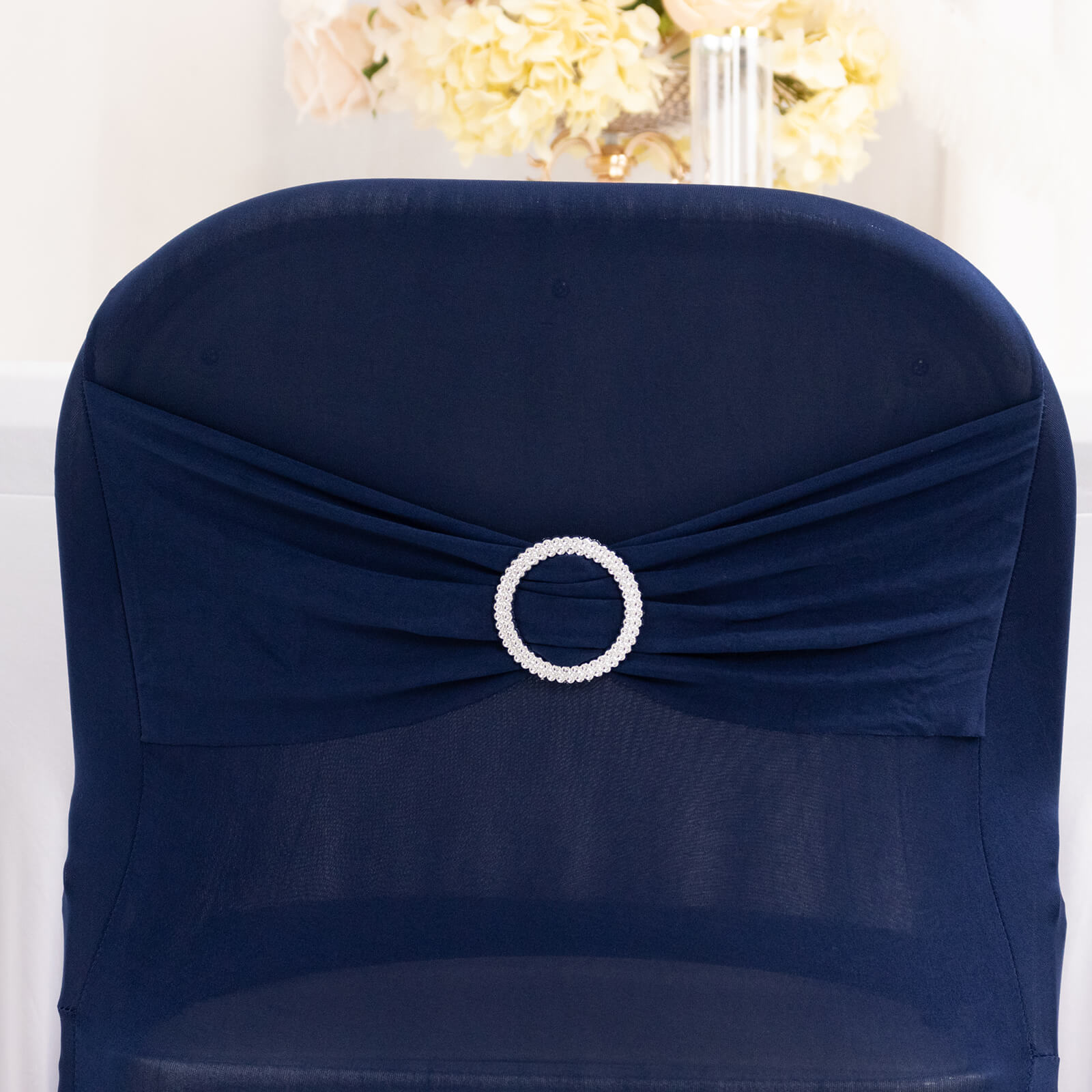 Navy blue spandex folding chair cover with silver rhinestone sash.