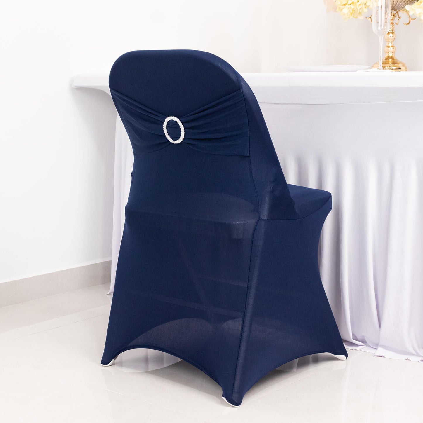 Navy blue spandex folding chair cover with silver rhinestone sash.