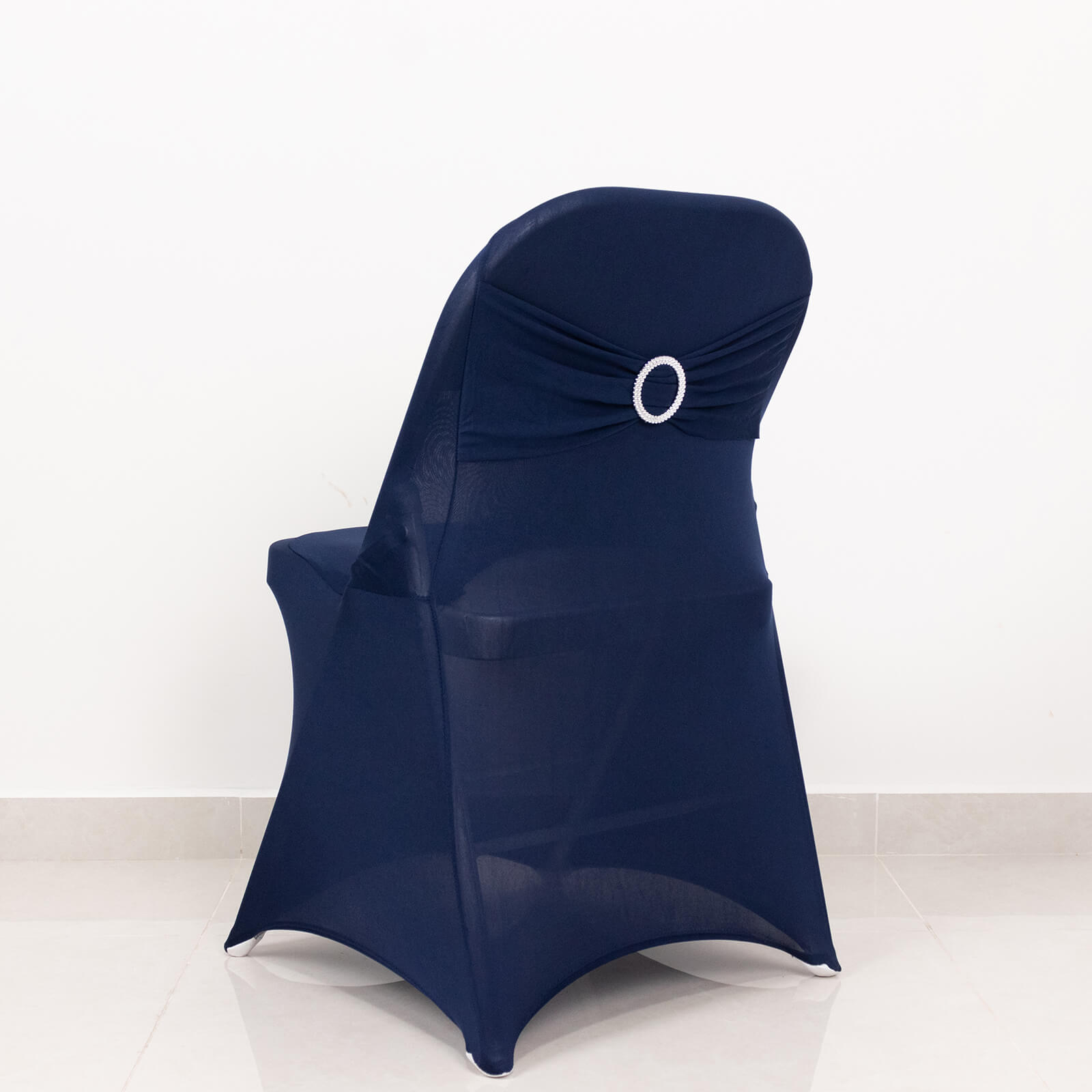 Navy blue spandex folding chair cover with silver rhinestone sash.