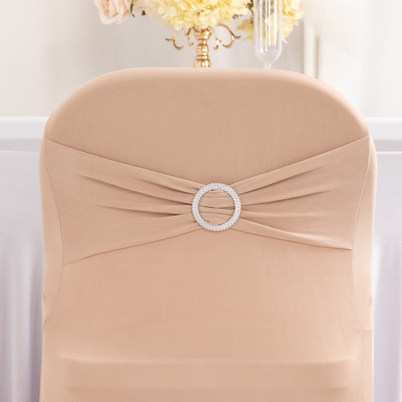 Nude spandex folding chair cover with silver rhinestone buckle.
