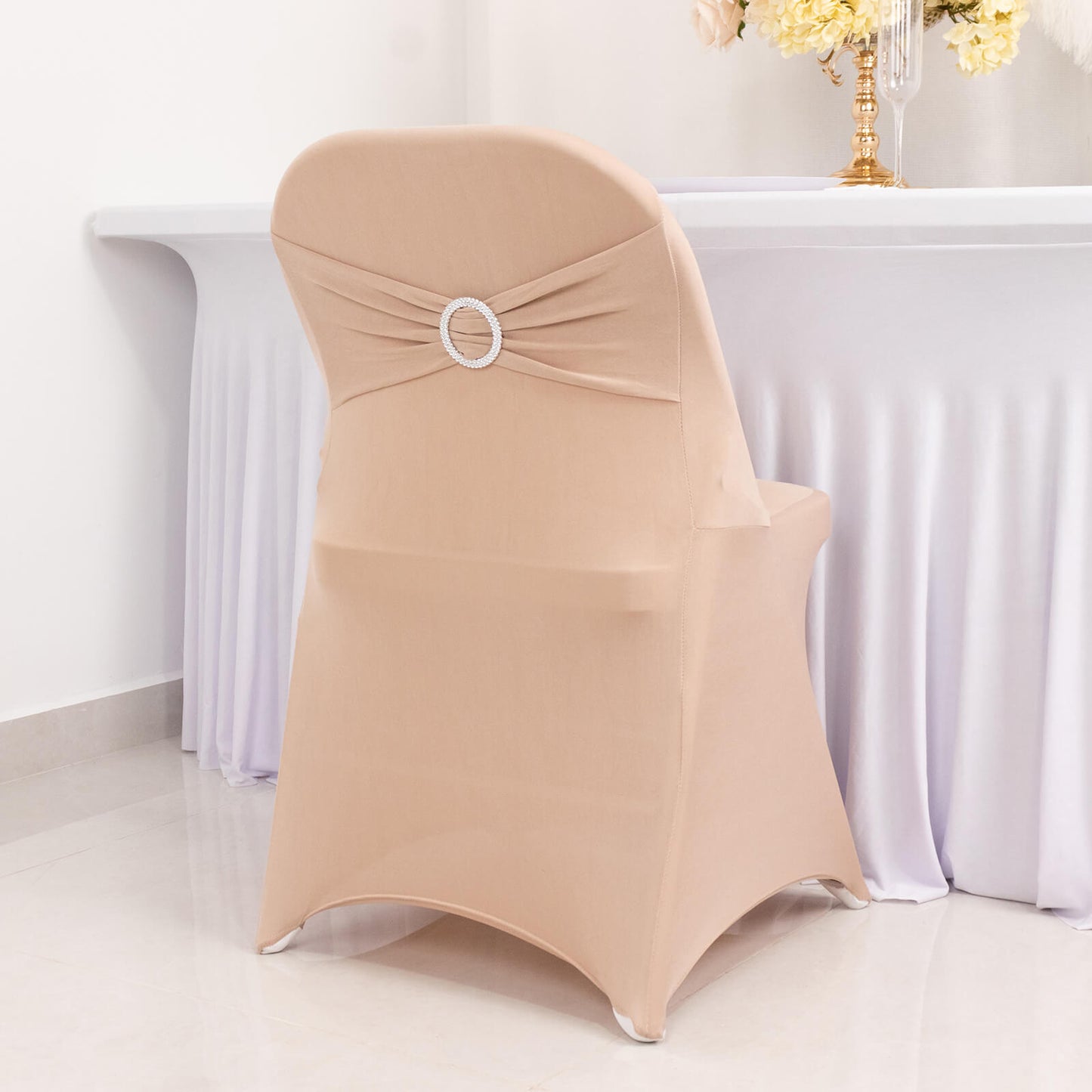 Nude spandex folding chair cover with rhinestone sash band.