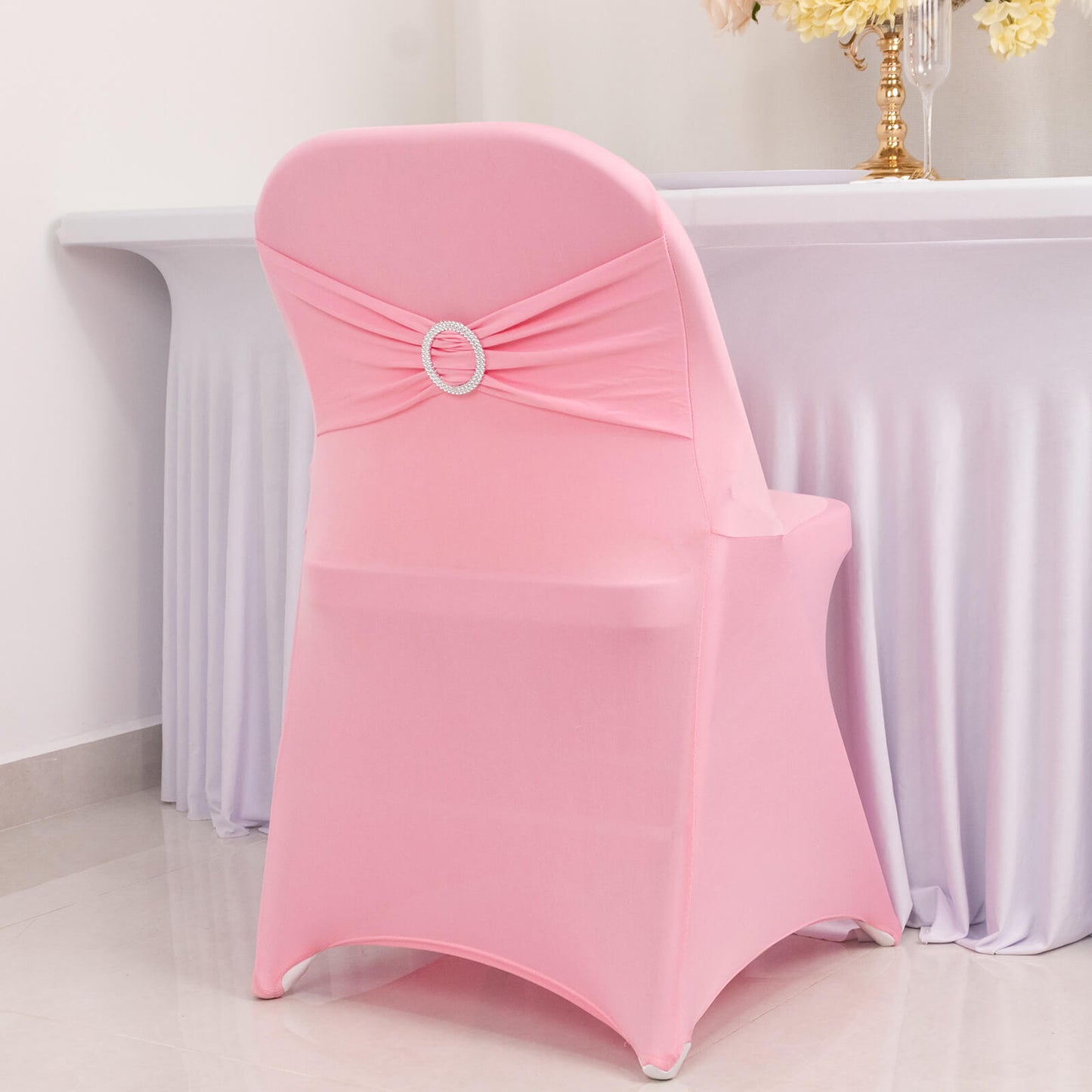 Pink spandex folding chair cover with silver rhinestone sash.