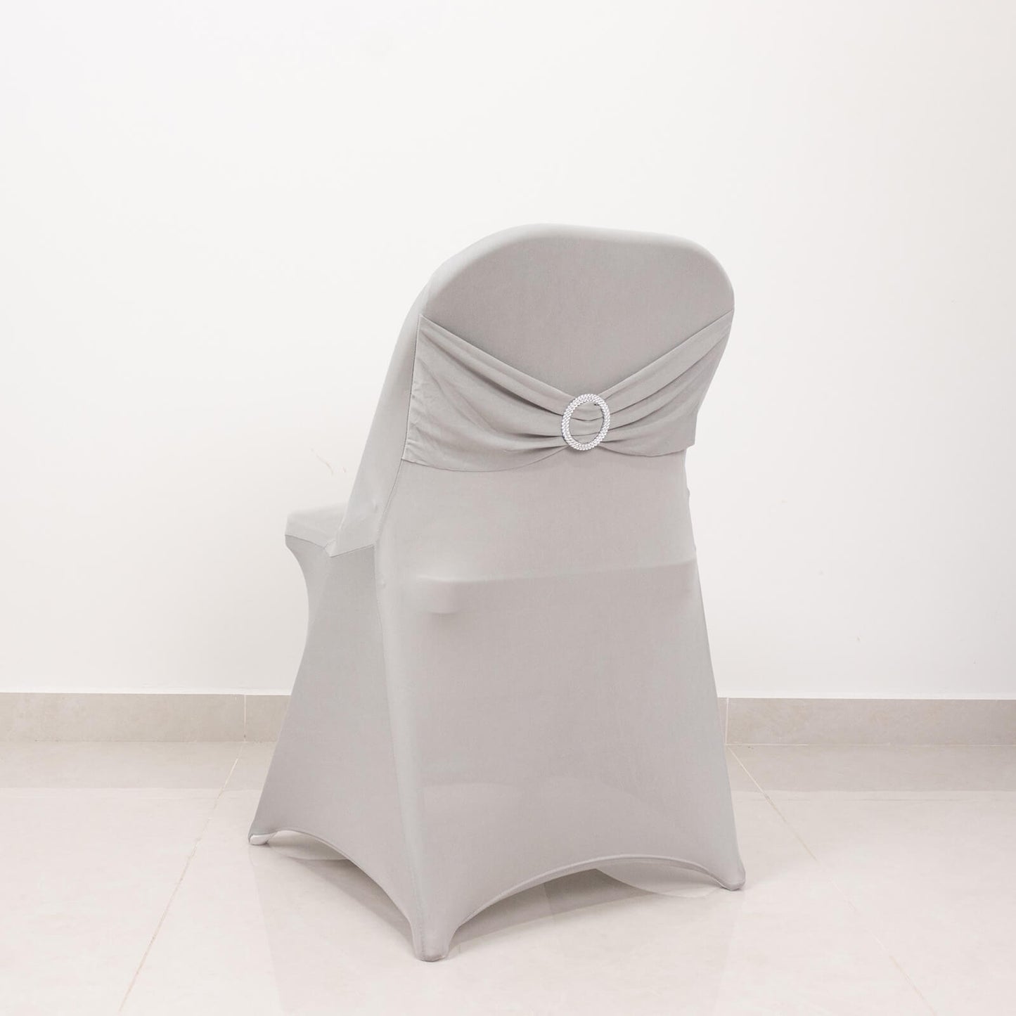 Silver spandex folding chair cover with rhinestone buckle sash.