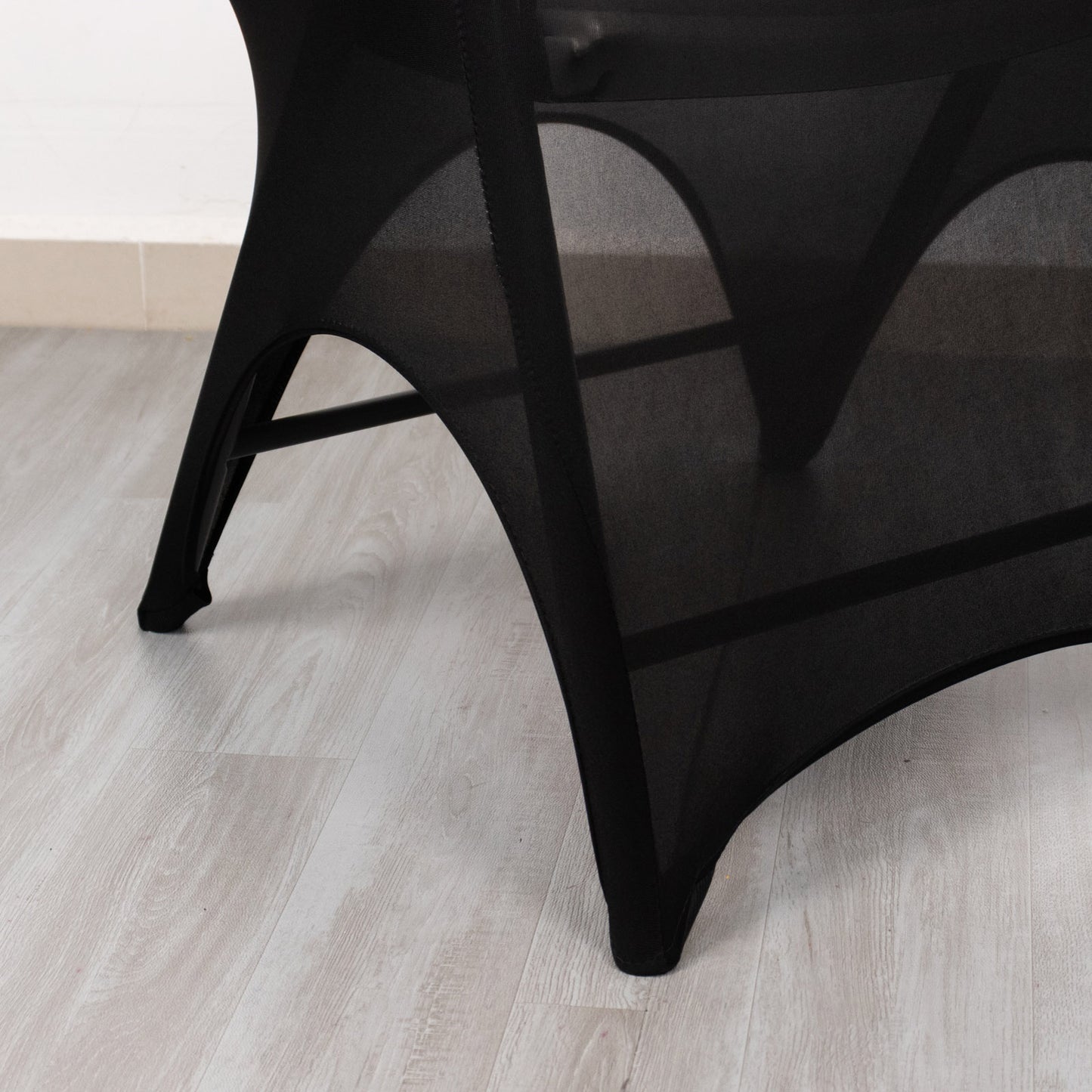 Black spandex wedding chair cover with open arch and foot pockets.