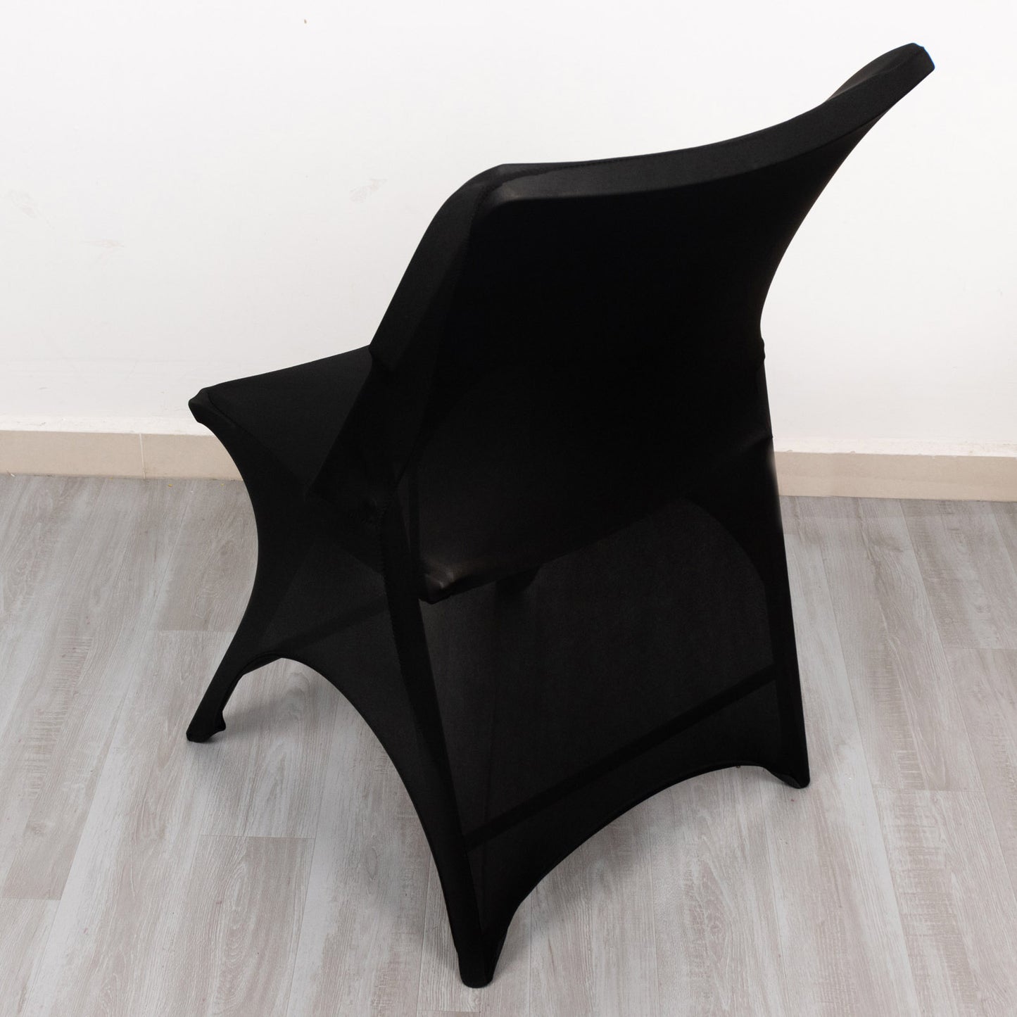Black spandex wedding chair cover with foot pockets and open arch design.