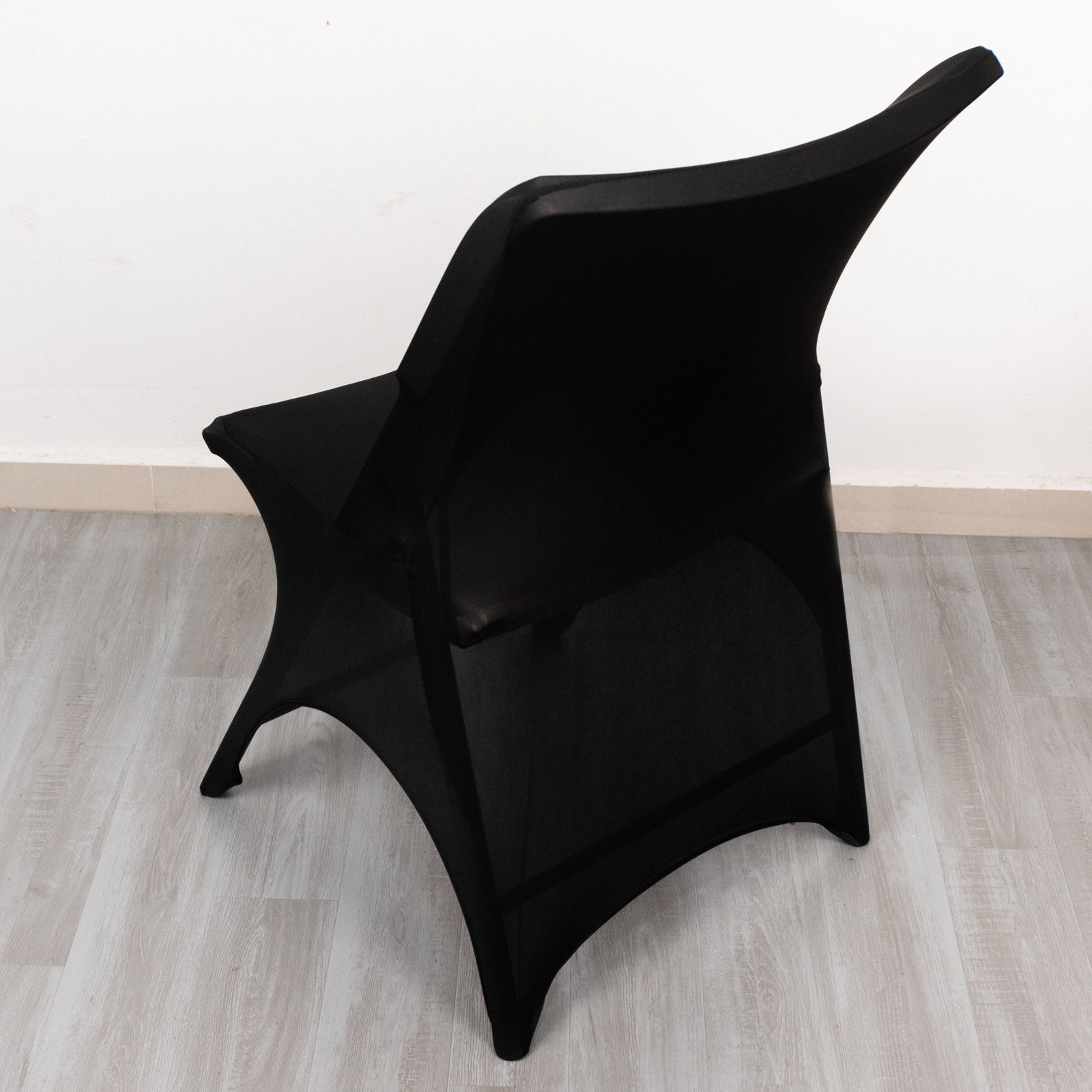 Black spandex wedding chair cover with foot pockets and open arch design.