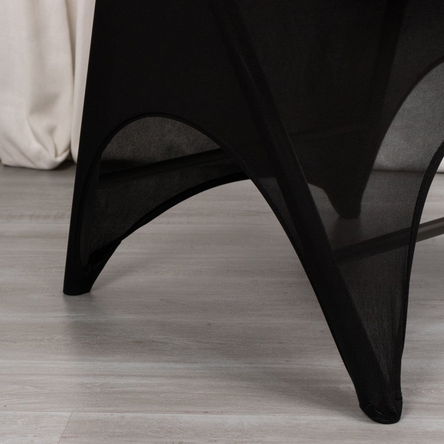 Black spandex wedding chair cover with open arch design.