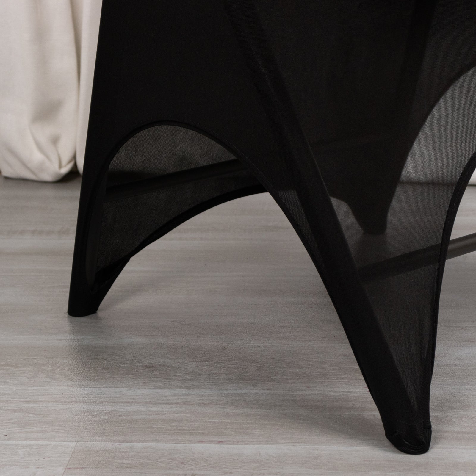 Black spandex wedding chair cover with open arch design.