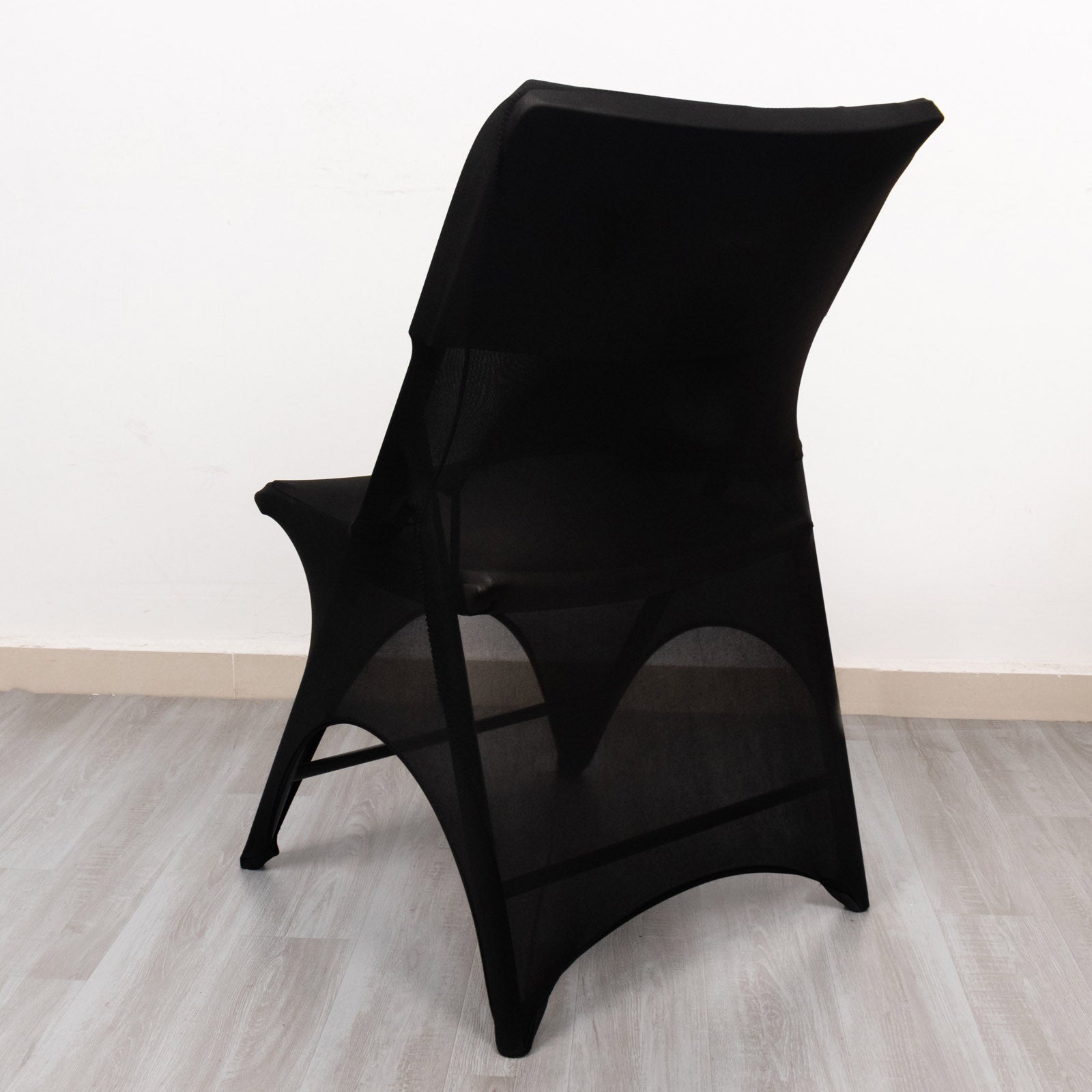Black spandex wedding chair cover with open arch design.