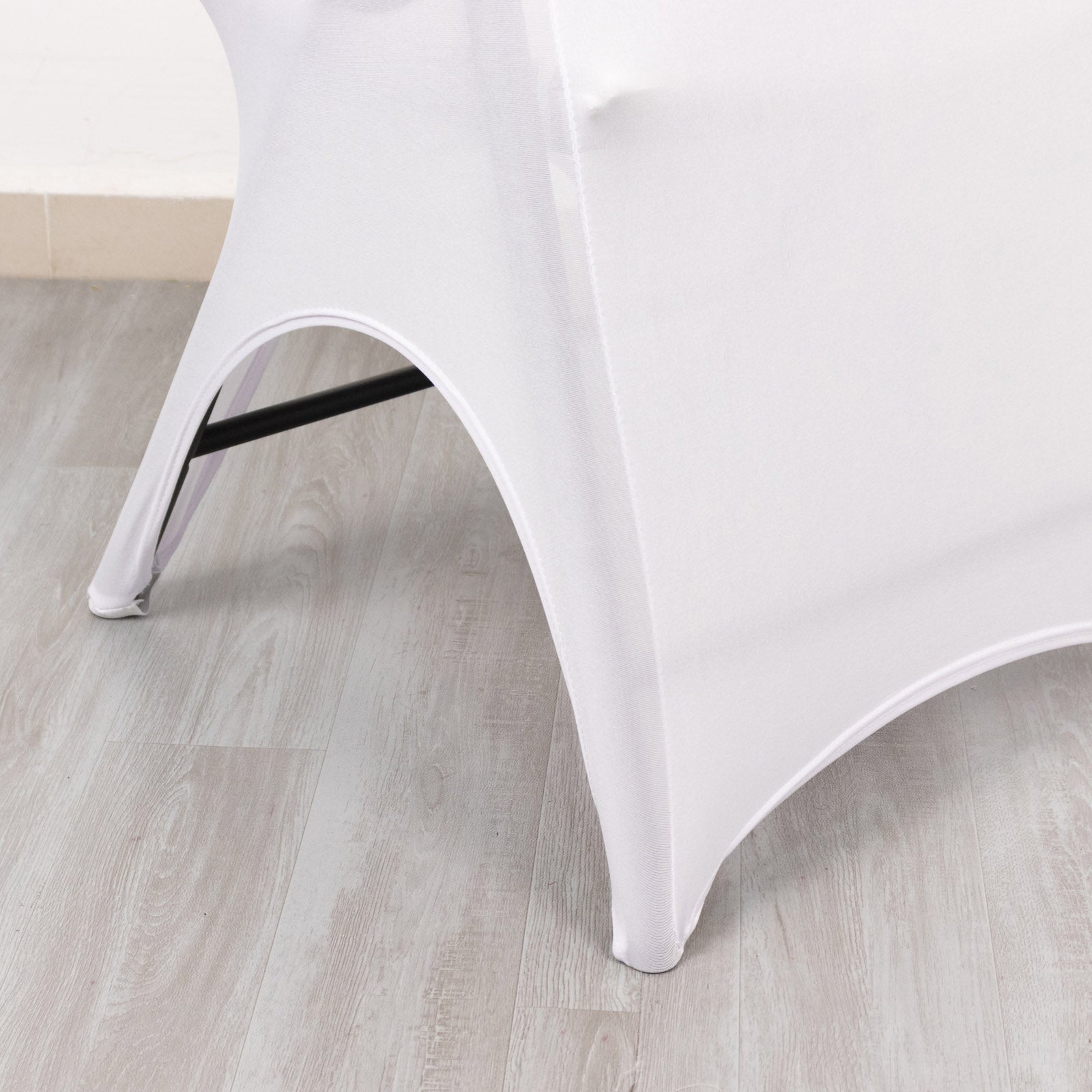 White spandex wedding chair cover with foot pockets and open arch design.
