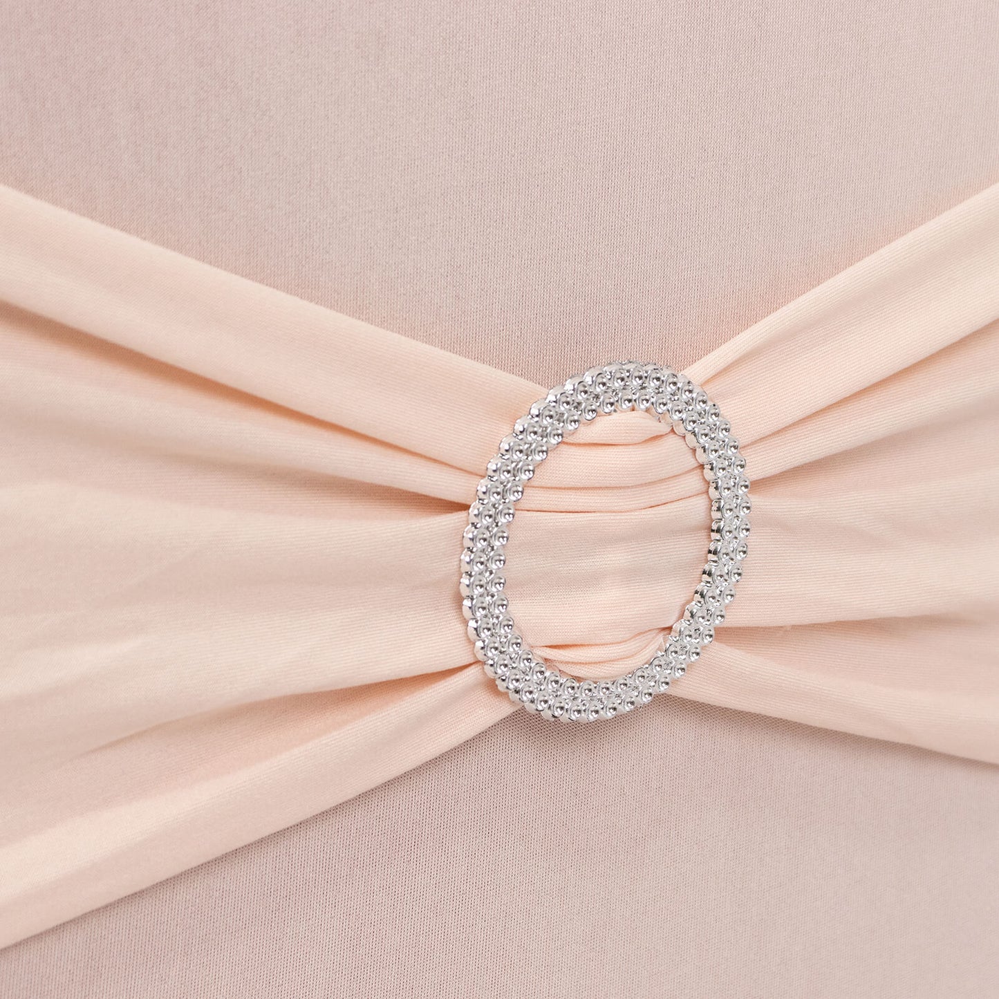 Blush spandex chair cover with silver rhinestone buckle detail.