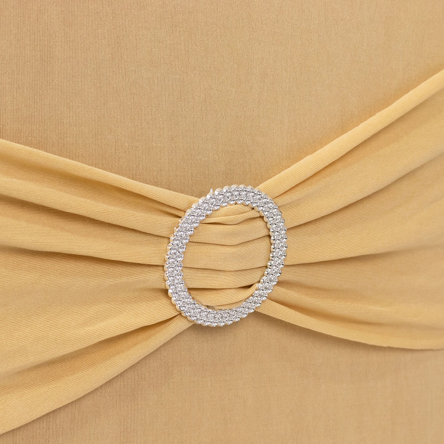 Champagne chair cover with silver rhinestone sash detail.