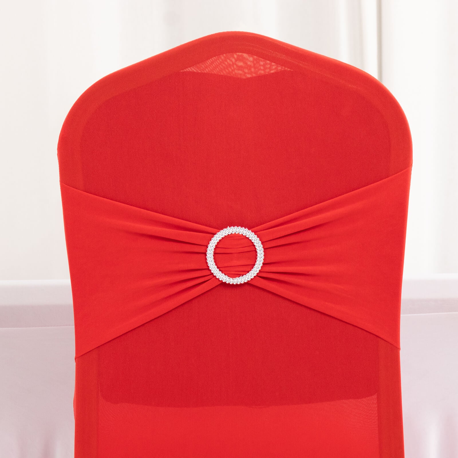 Red spandex banquet chair cover with silver rhinestone buckle.