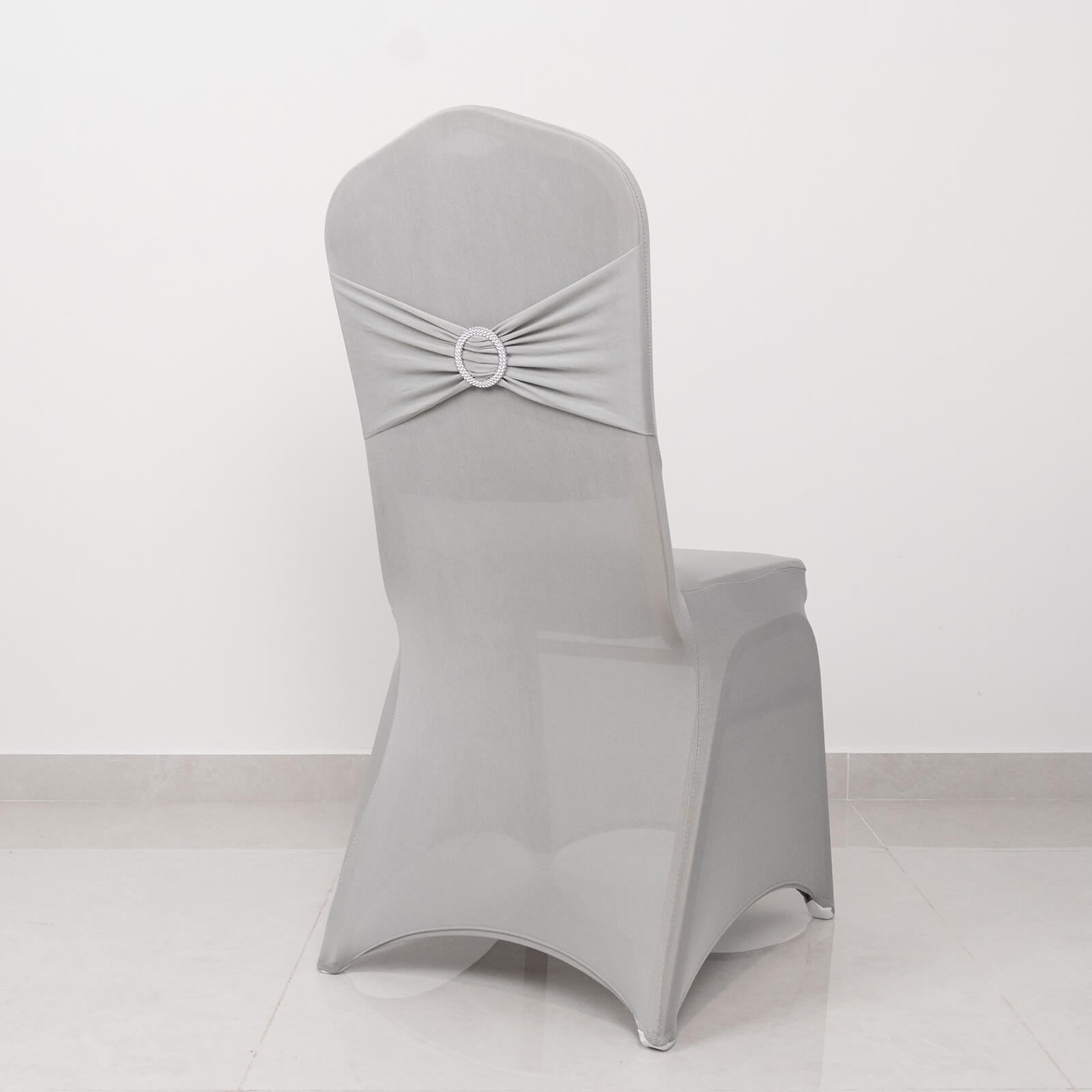 Silver spandex banquet chair cover with rhinestone sash.