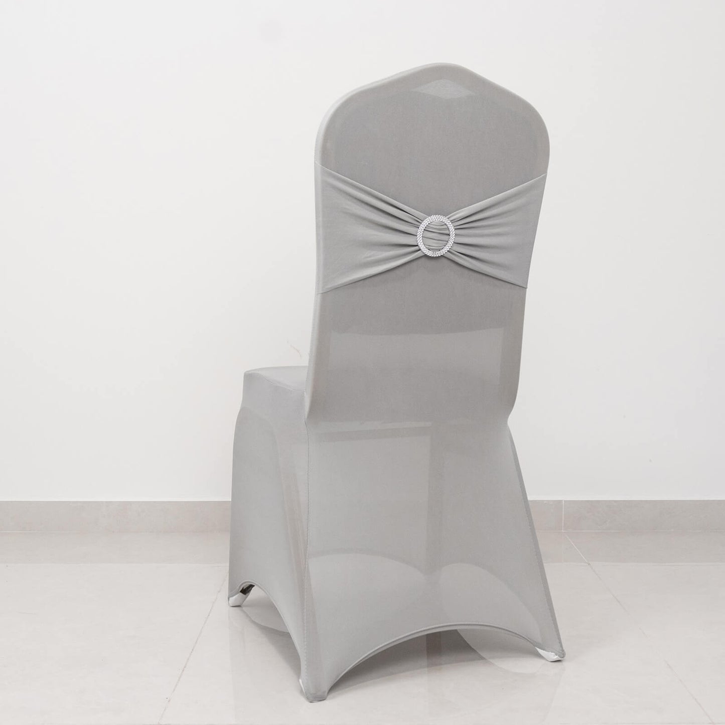 Silver spandex banquet chair cover with rhinestone sash.