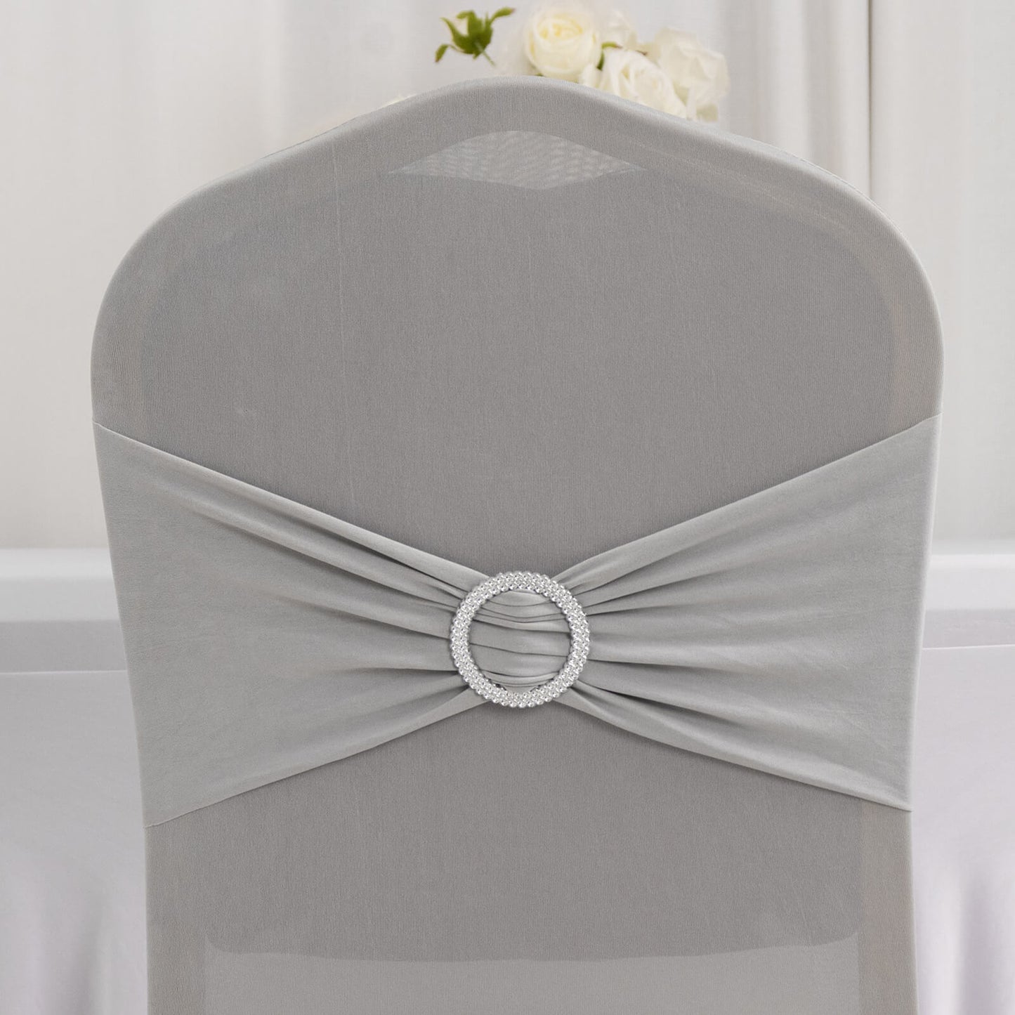 Silver spandex banquet chair cover with rhinestone buckle sash.