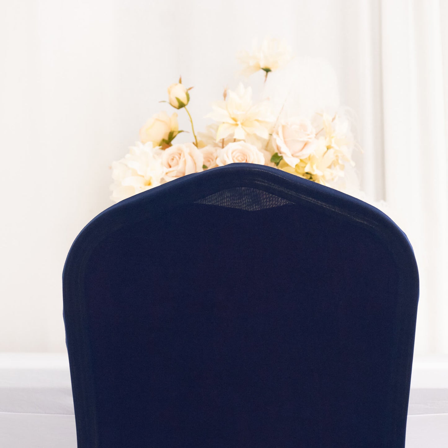 Navy ruffle pleated chair slipcover with floral backdrop.