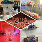 32" tall acrylic crystal chandelier centerpiece with floral arrangements in vibrant colors.