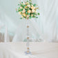 Gold acrylic crystal candle stand with floral arrangement centerpiece.