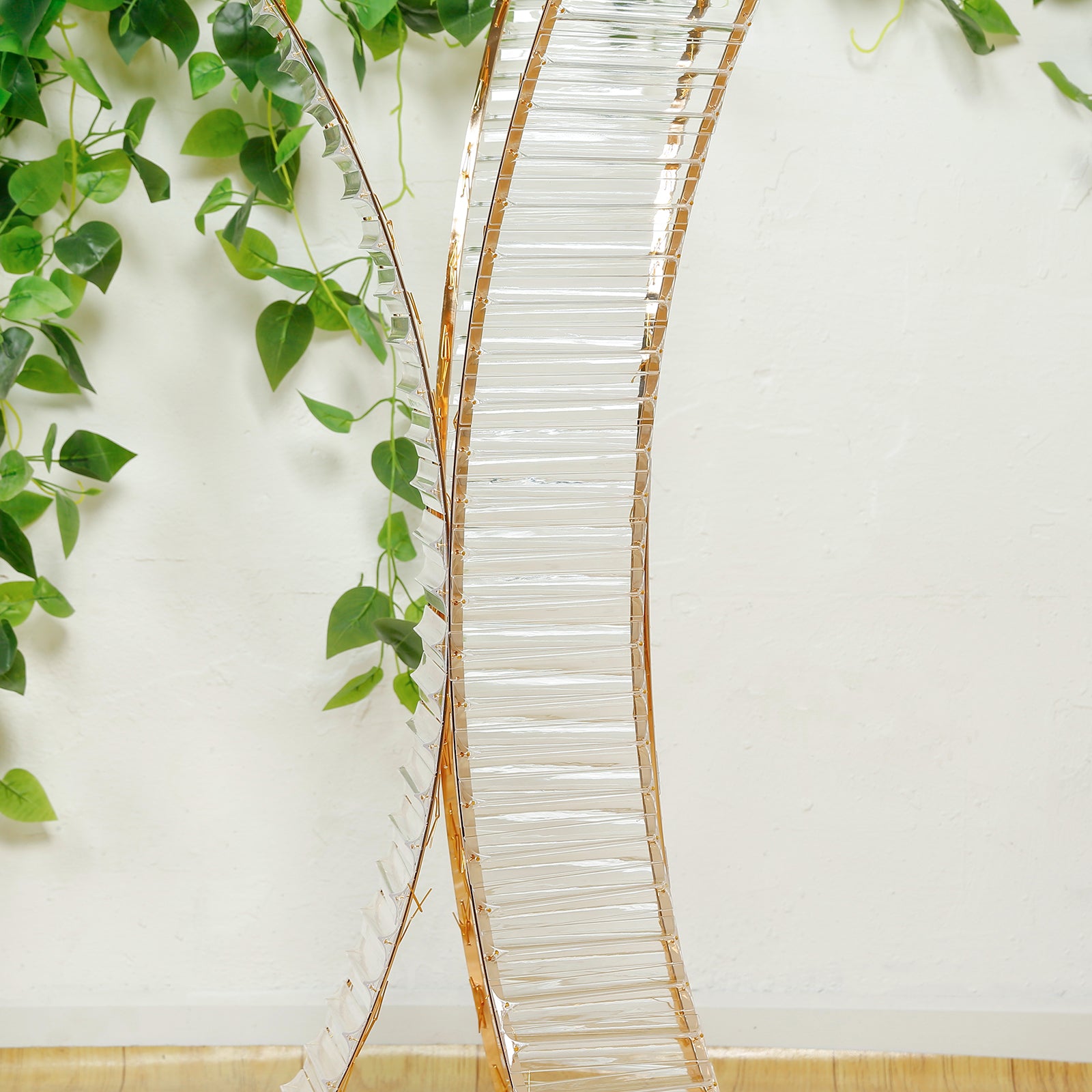 Gold metal frame hourglass vase with crystal pendant for floral arrangements.