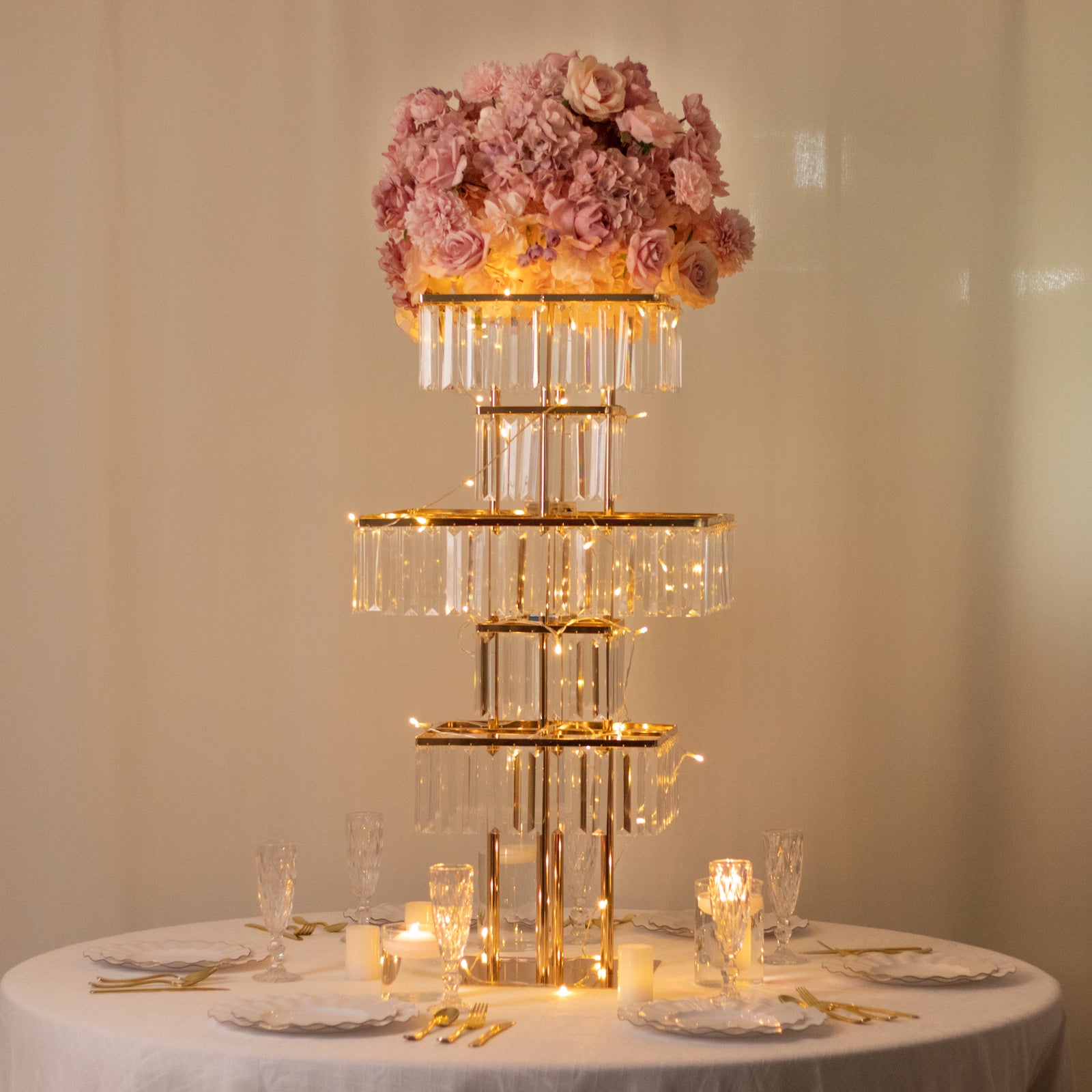 Gold crystal chandelier table centerpiece with pink floral arrangement.