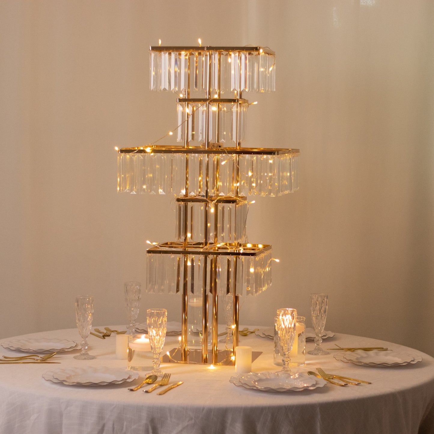 Gold crystal chandelier centerpiece with hanging crystals on a table.