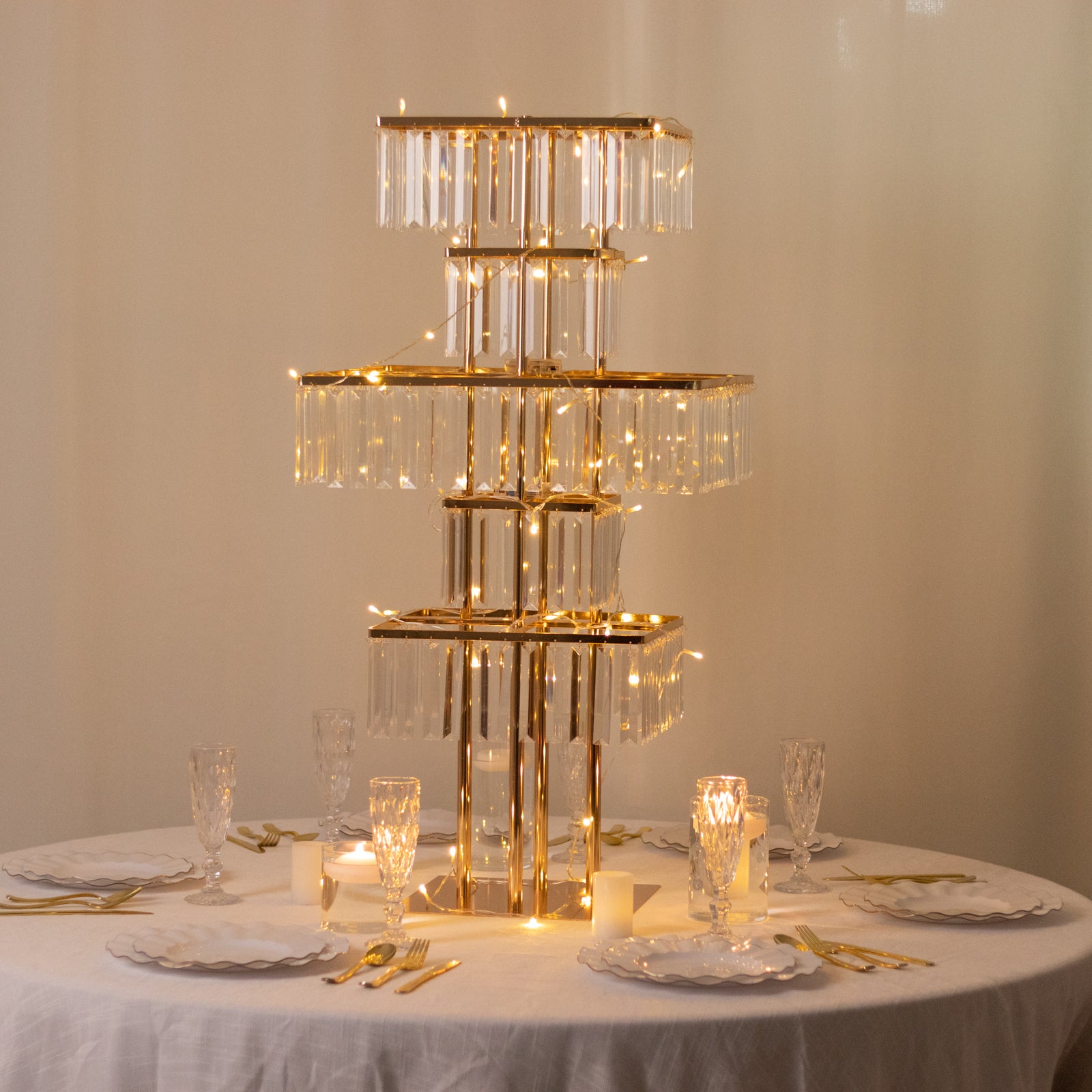 Gold crystal chandelier centerpiece with hanging crystals on a table.