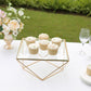 Gold geometric cake stand with square glass top displaying cupcakes.