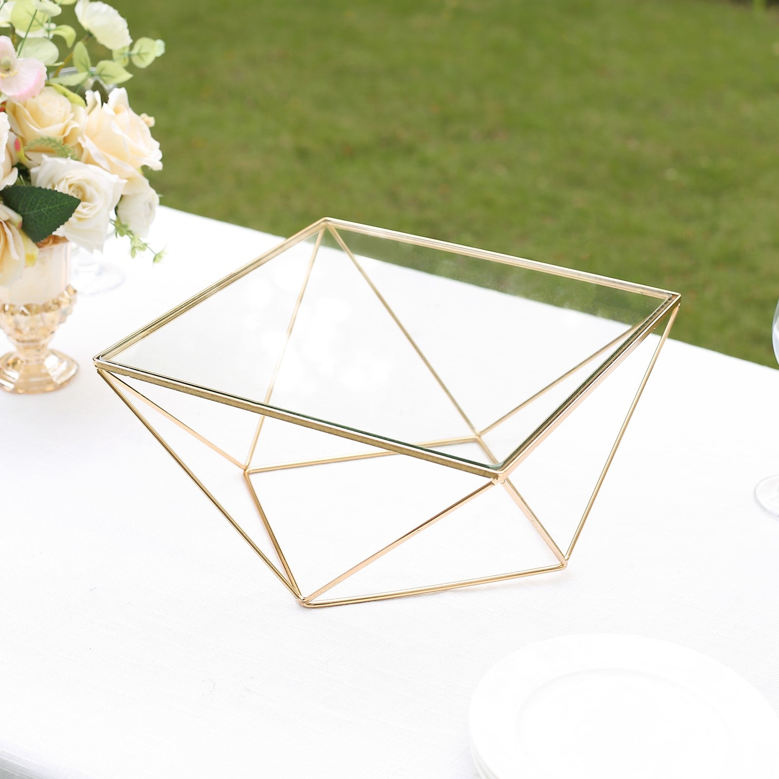Gold geometric cake stand with square glass top centerpiece display.