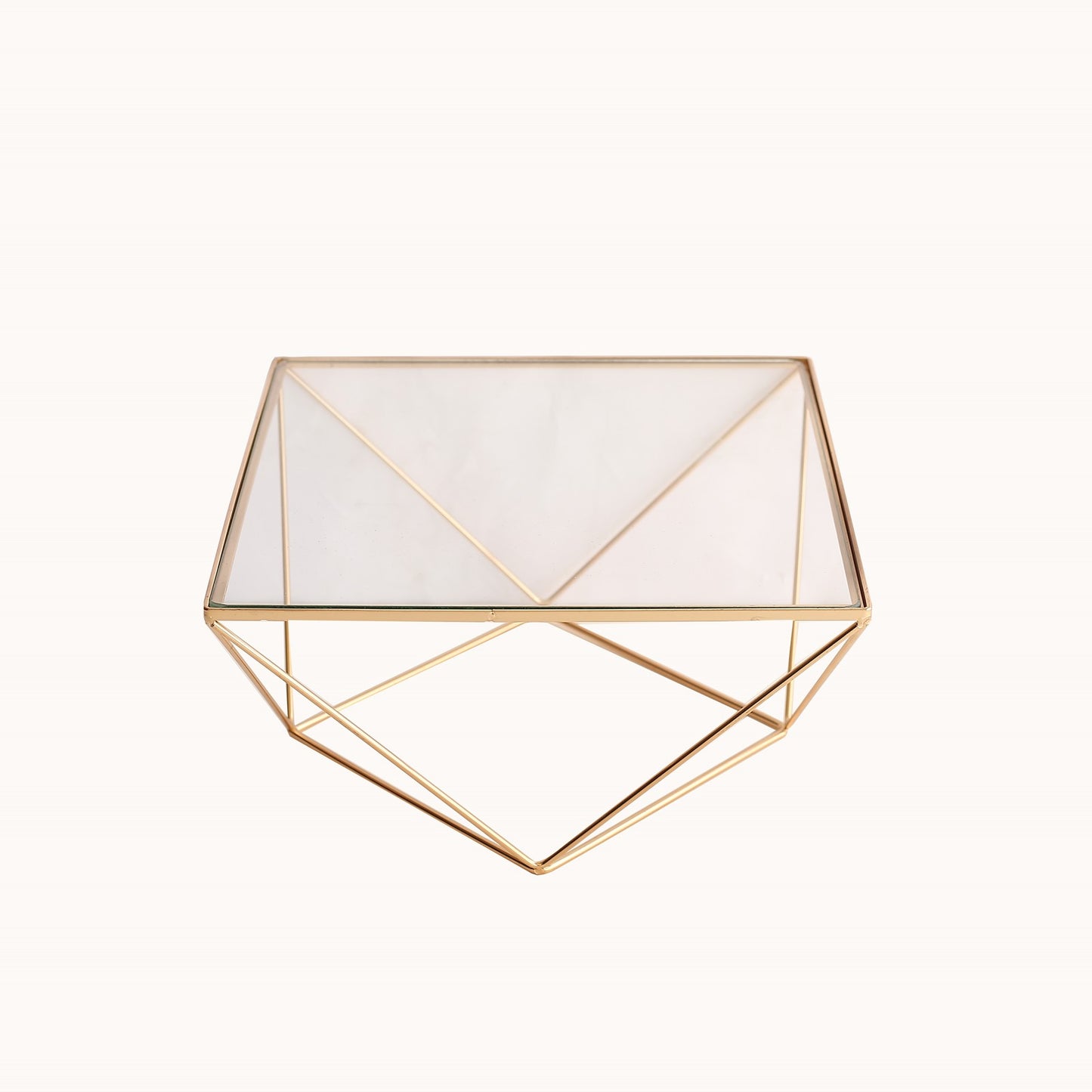 Gold metal geometric cake stand with square glass top.