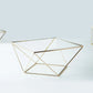Gold geometric cake stand with square glass top.