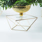 Gold geometric cake stand with square glass top, perfect for displays.